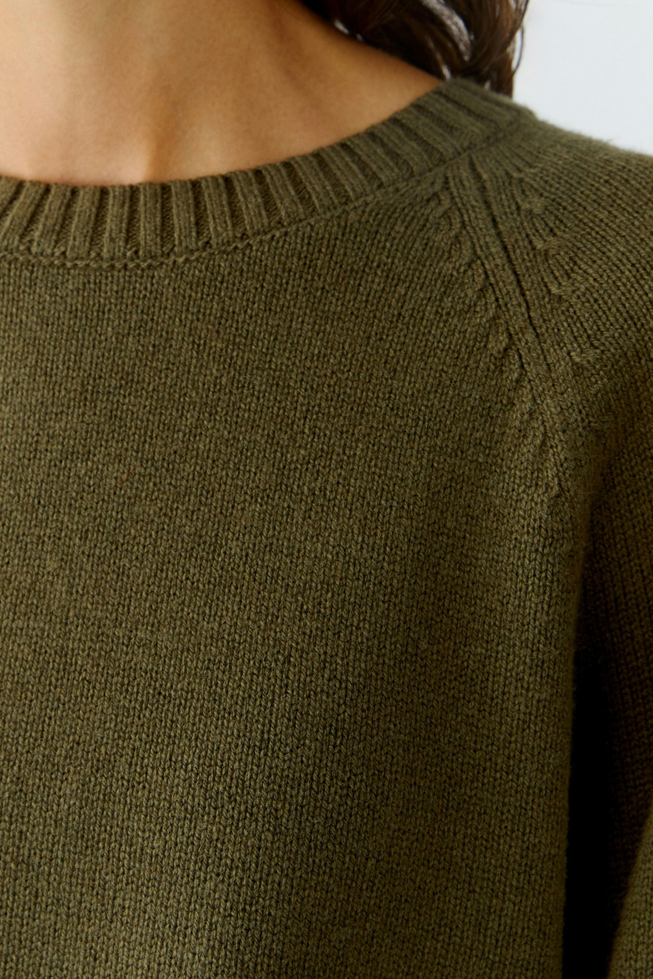 Casual women's pullover in olive green with a round neckline and textured details.
