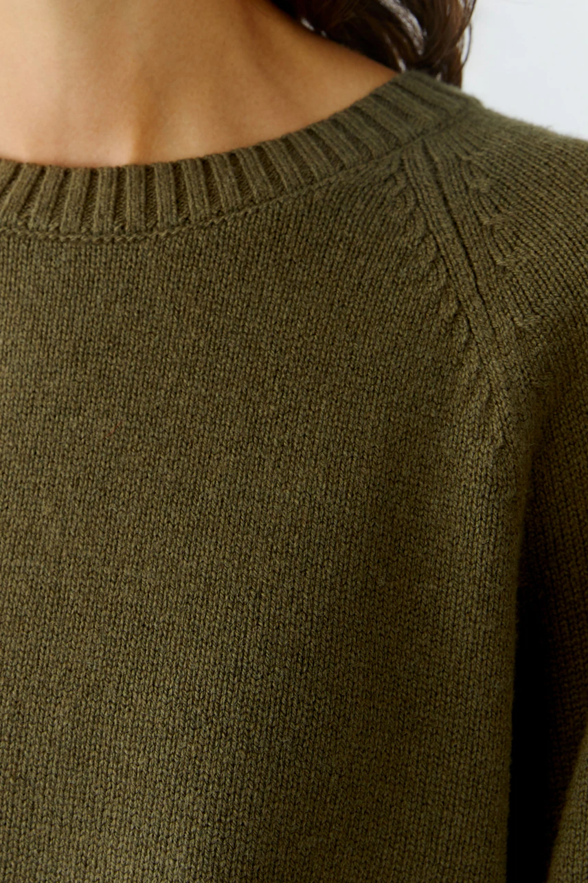 Casual women's pullover in olive green with a round neckline and textured details.