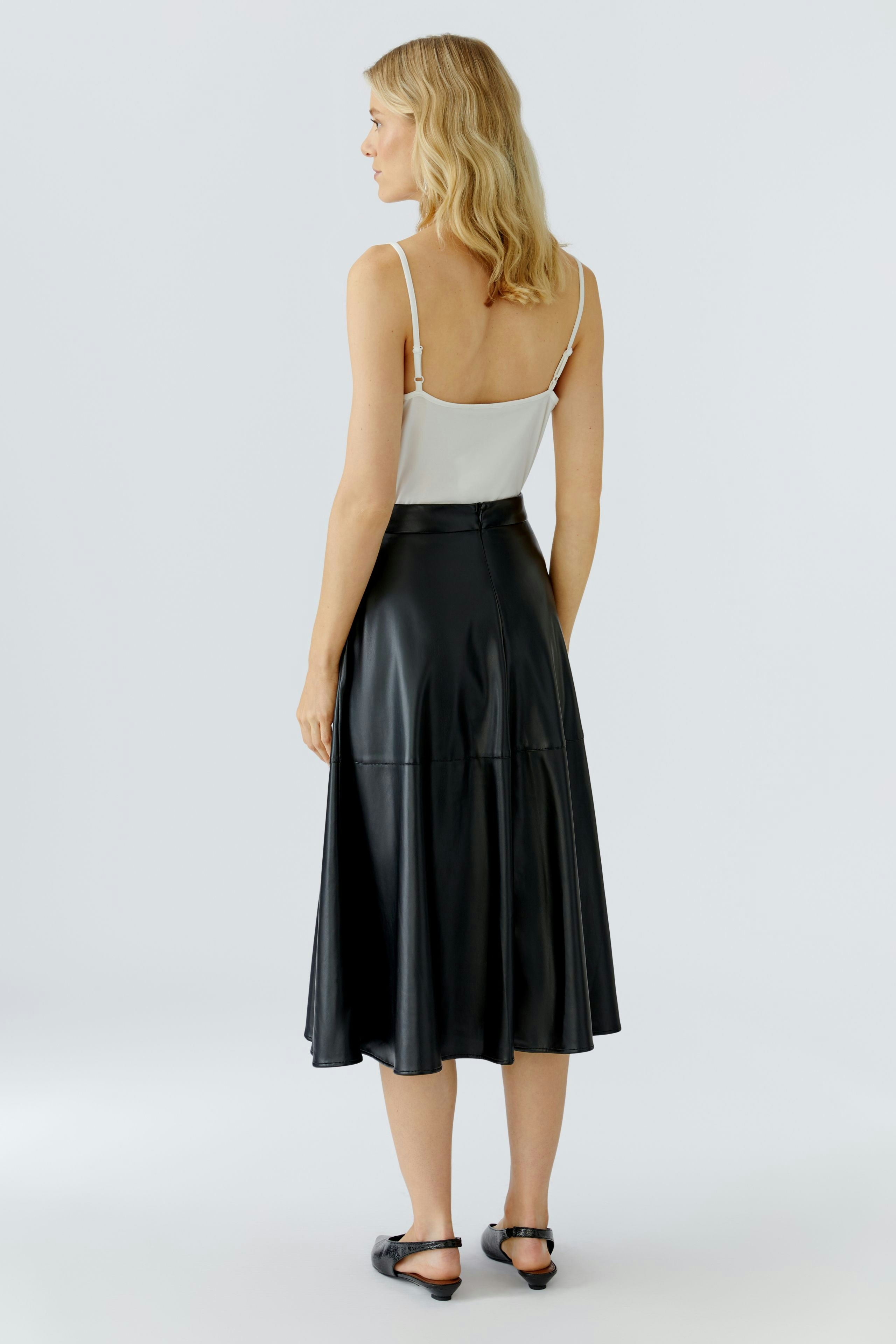 A-line skirt: Woman in a black A-line skirt with a flowy design, showcasing a casual style.