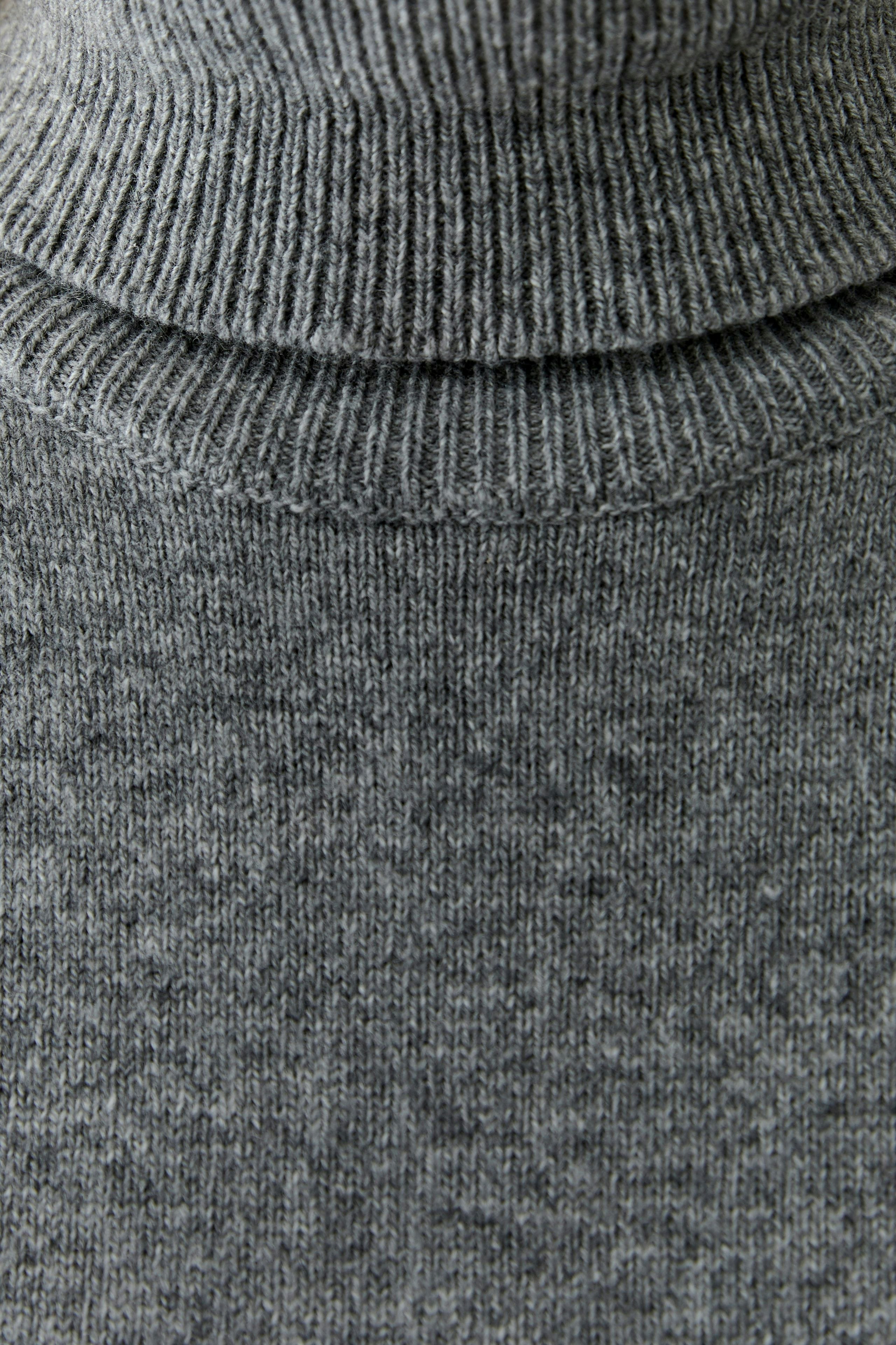 Casual women's pullover: Close-up of a gray turtleneck pullover, soft texture and versatile style.