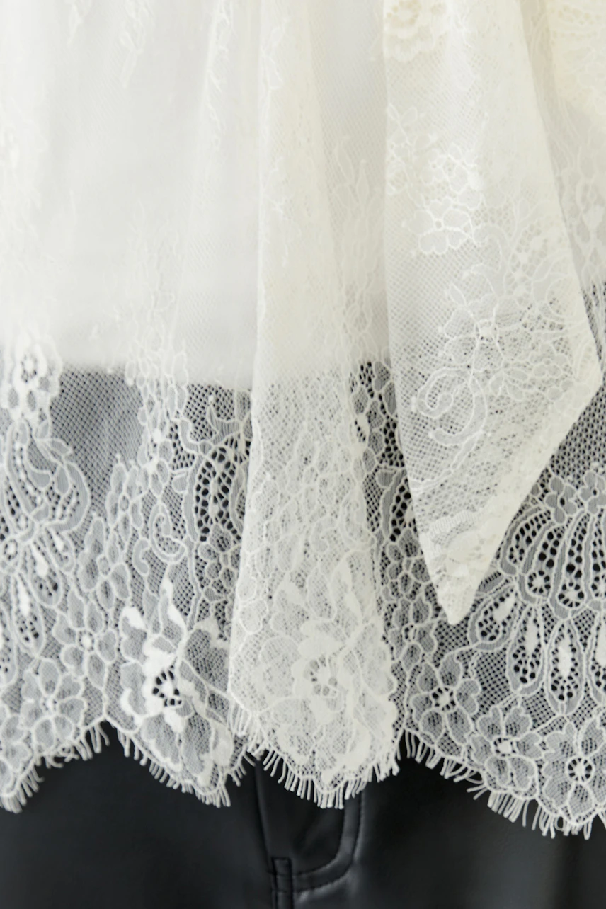 Chic women's blouse with lace details and a tied neck, showcasing a stylish and modern look.