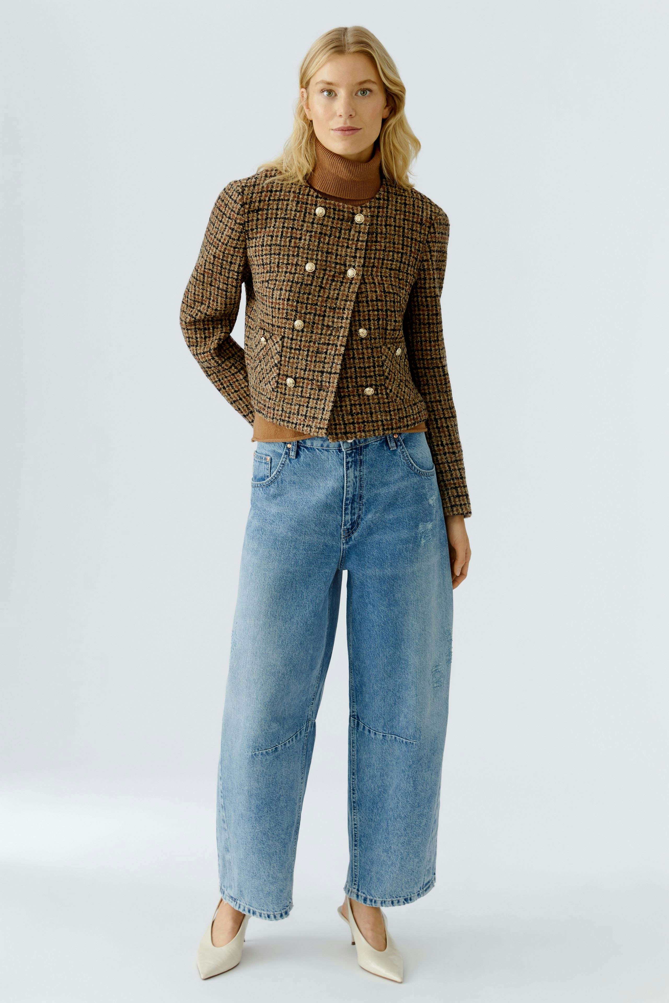 Casual women's jeans: A woman in light blue barrel jeans paired with a stylish checkered jacket.