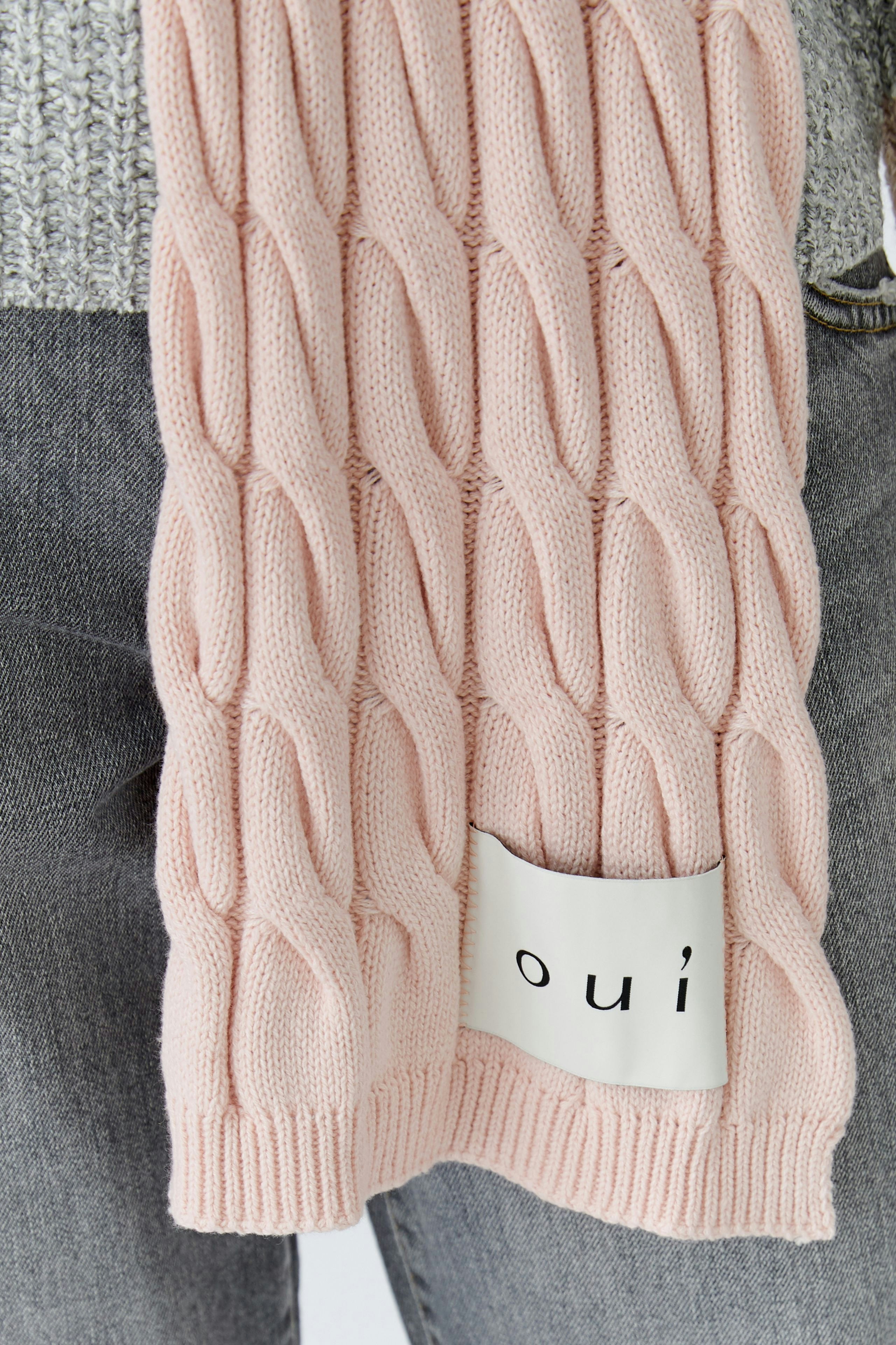 Cozy women's scarf in soft pink with a textured cable knit design, perfect for layering.