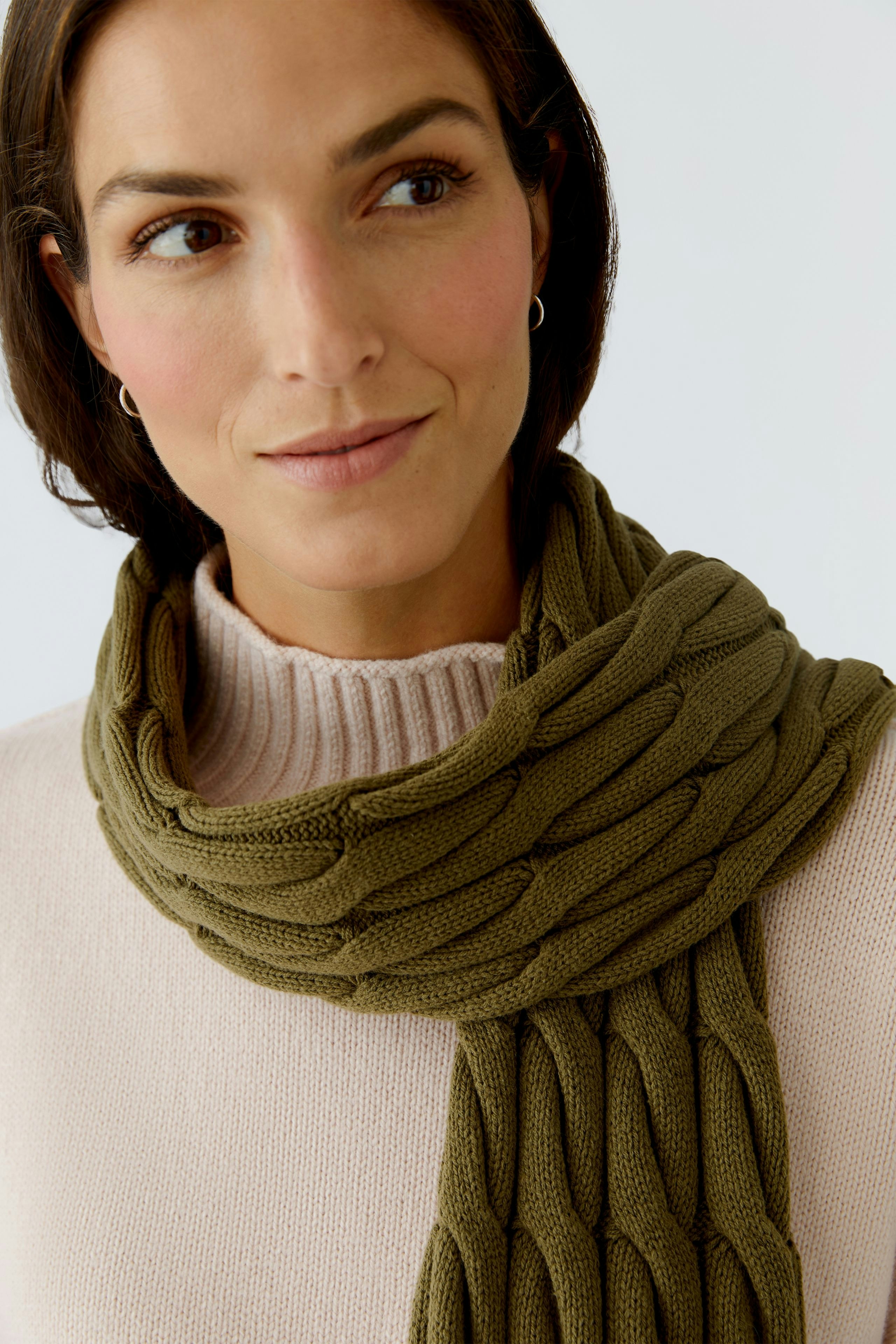 Cozy women's scarf in olive green, featuring a textured knit design, worn with a light pullover.
