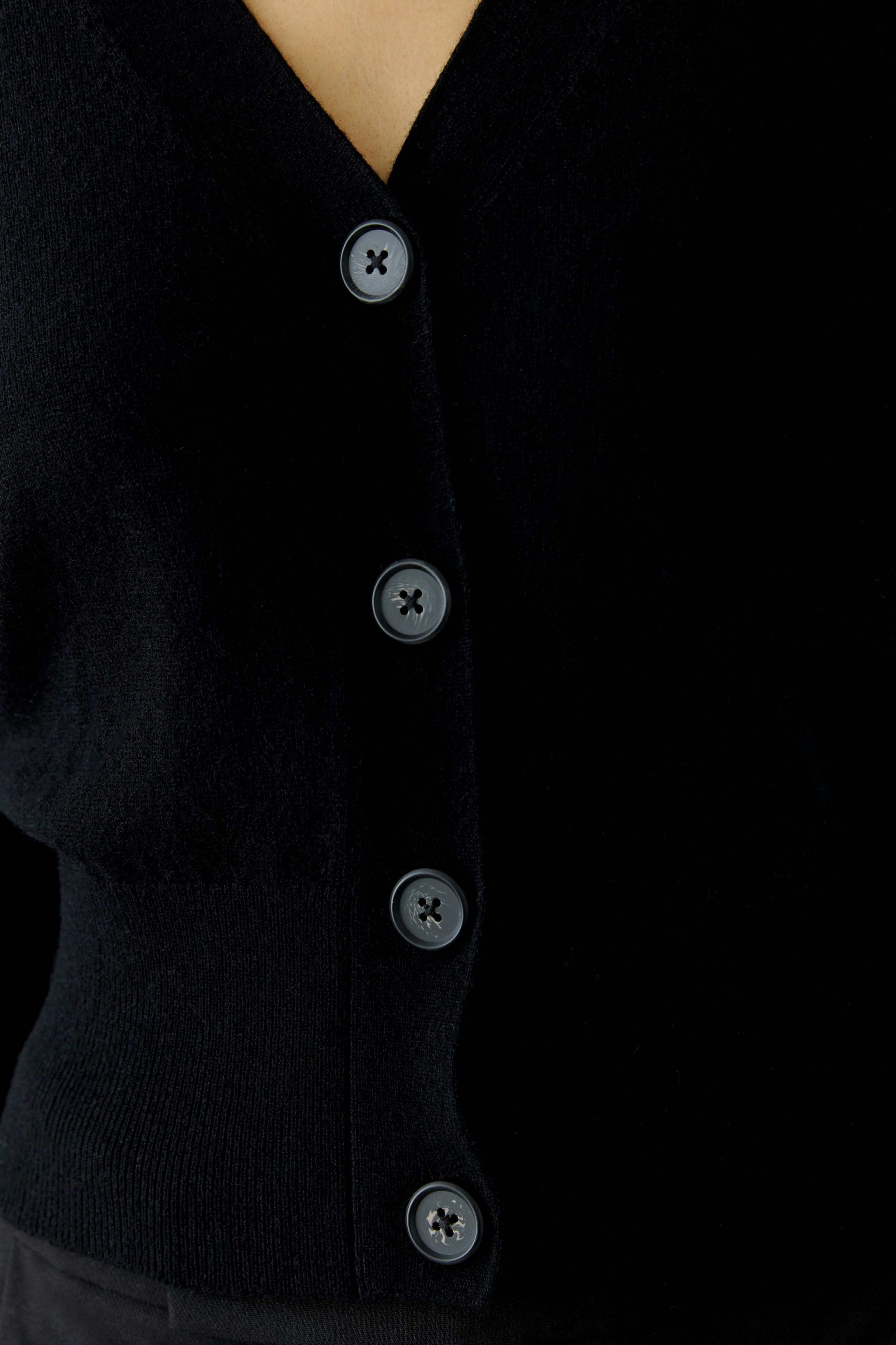Casual women's cardigan: A woman in a black cardigan with buttons, perfect for layering.