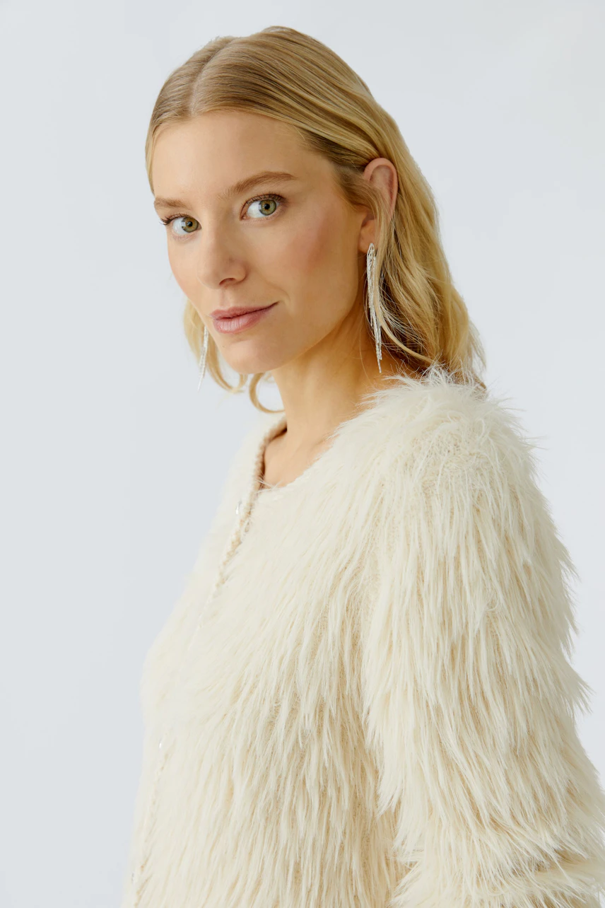 Casual women's cardigan: A woman in a fluffy white cardigan with a relaxed look.
