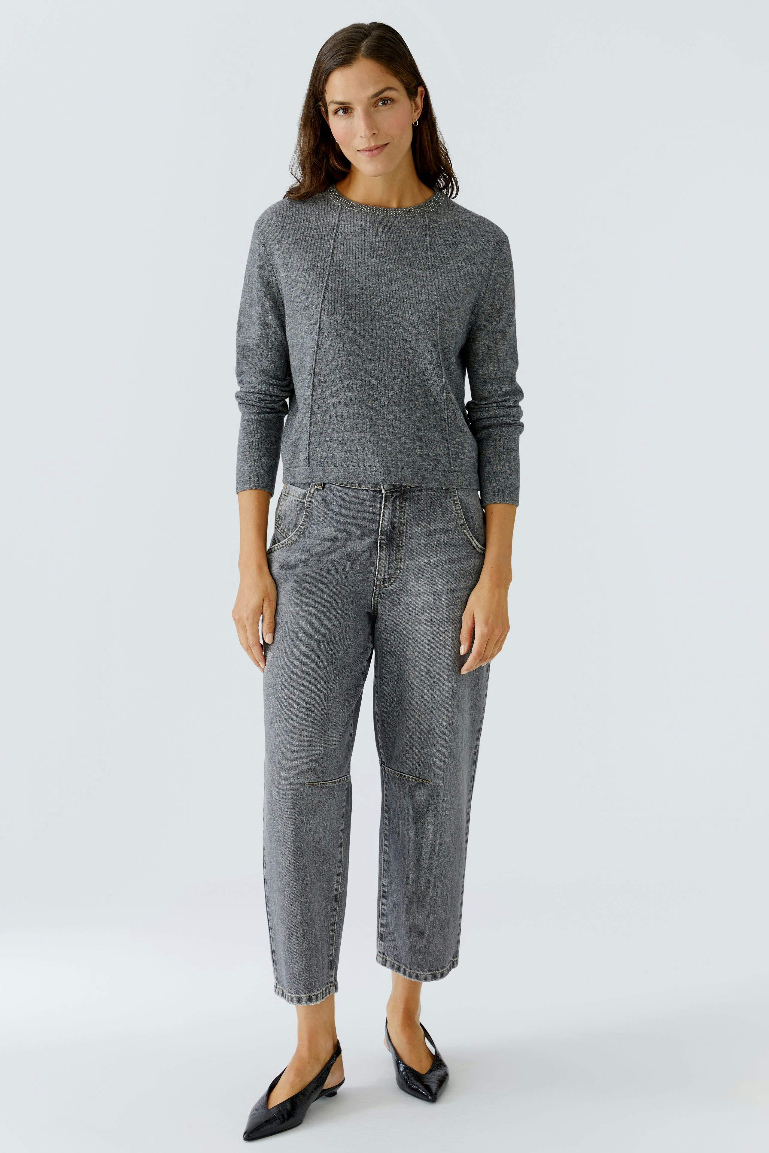 Casual women's pullover: A woman in a gray pullover paired with relaxed-fit jeans, exuding comfort.