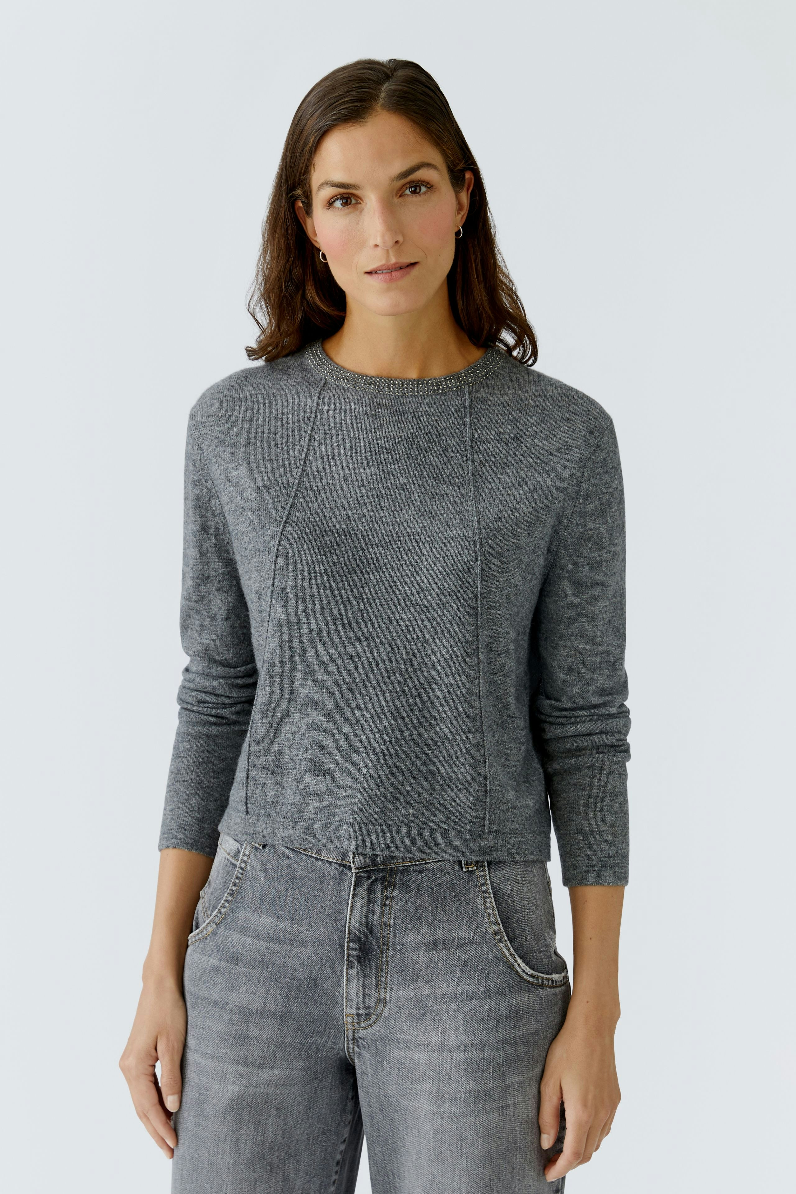 Casual women's pullover: Woman in a gray knitted pullover with three-quarter sleeves and relaxed fit.