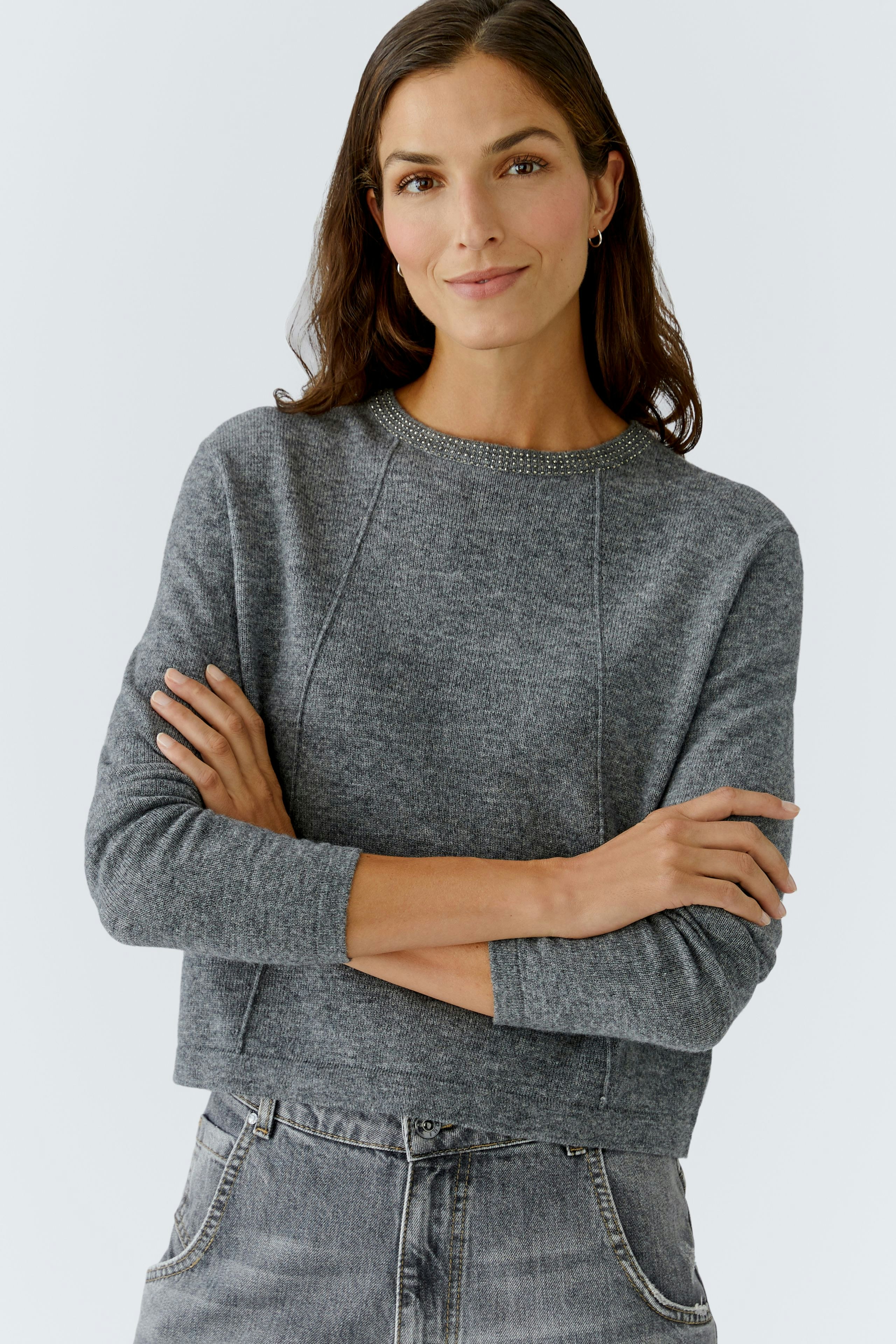 Casual women's pullover: A woman in a gray pullover with a relaxed fit and round neckline.