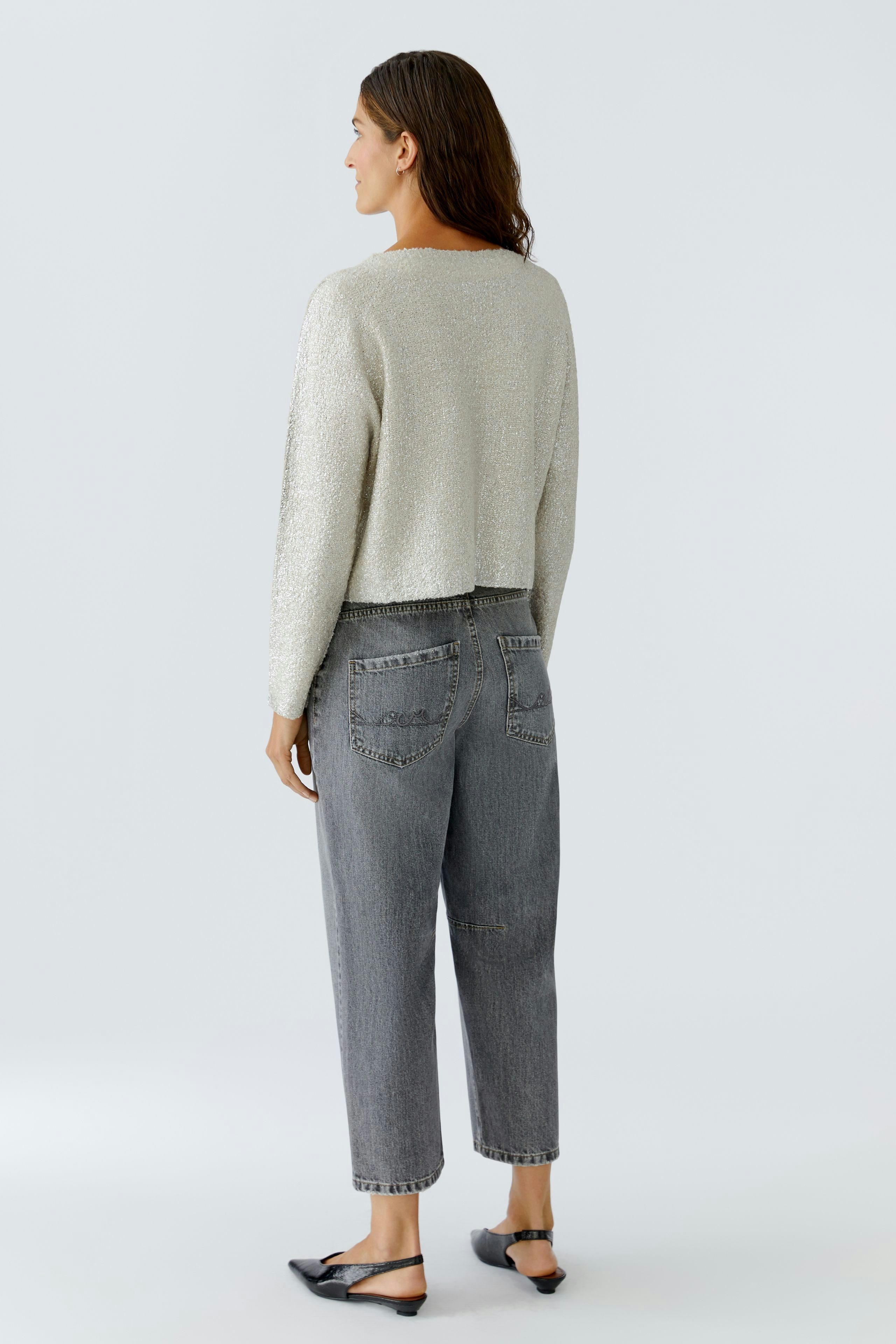 Casual women's pullover: A woman in a light gray cropped pullover with a relaxed fit and jeans.