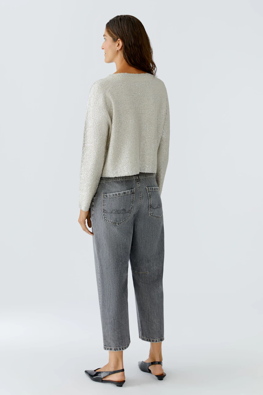 Casual women's pullover: A woman in a light gray cropped pullover with a relaxed fit and jeans.