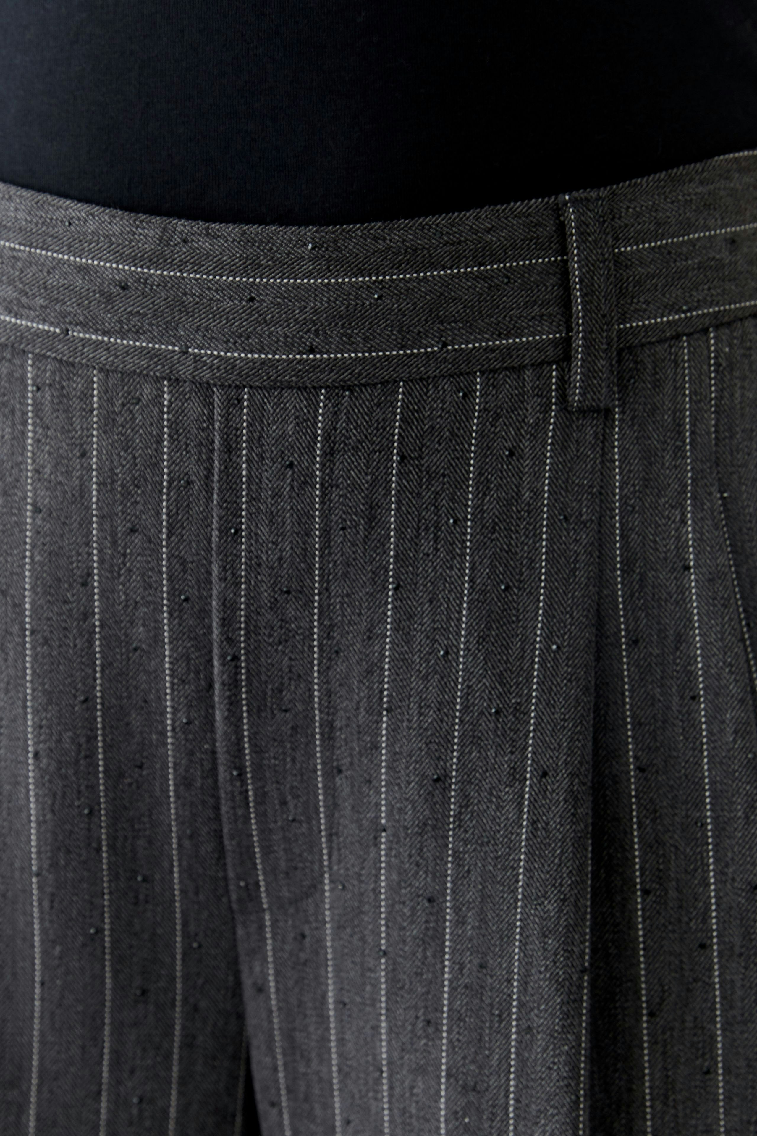 Stylish women's pleated trousers with a modern pinstripe design, perfect for casual wear.