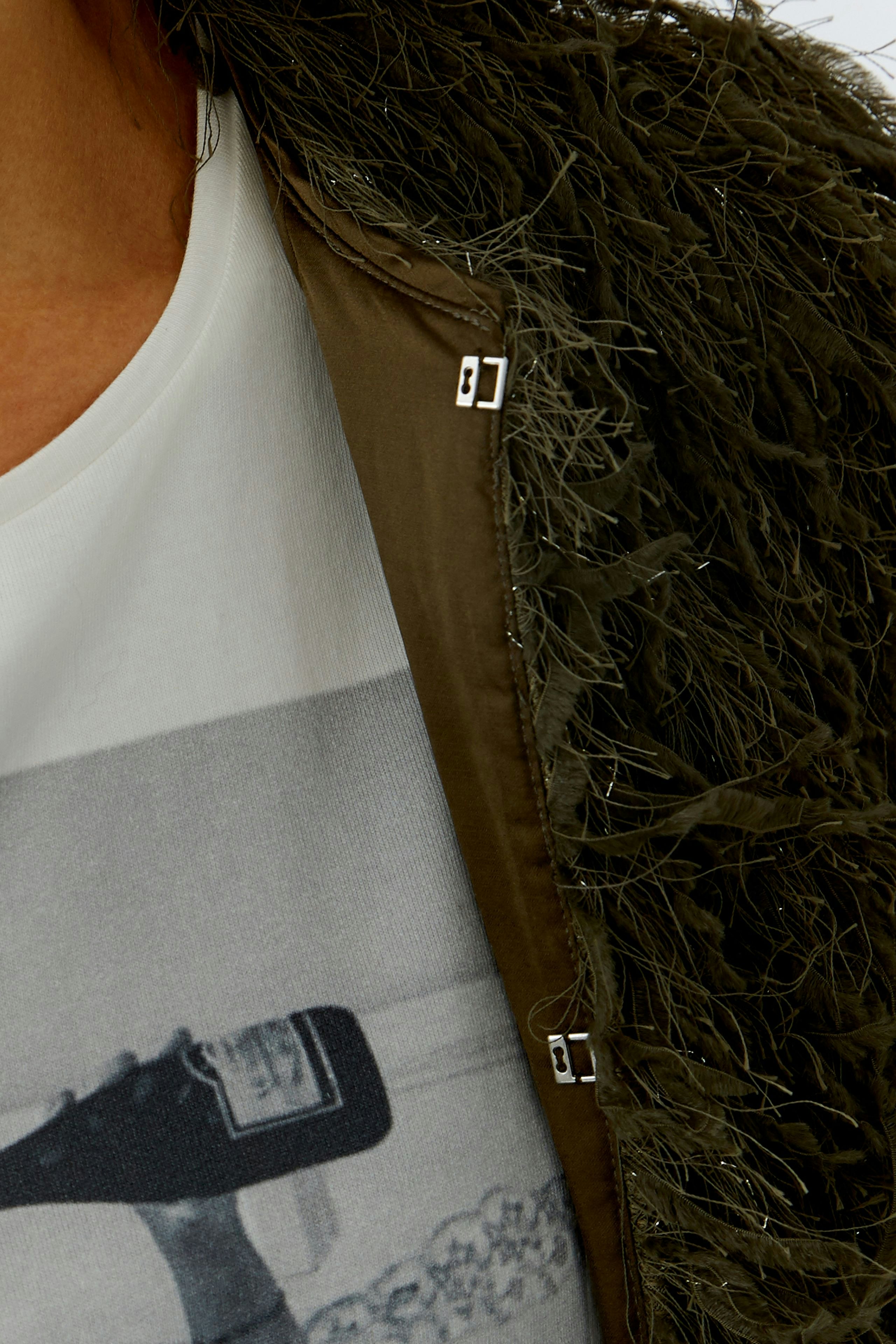 Casual women's jacket: Close-up of a woman wearing a textured green jacket over a graphic tee.