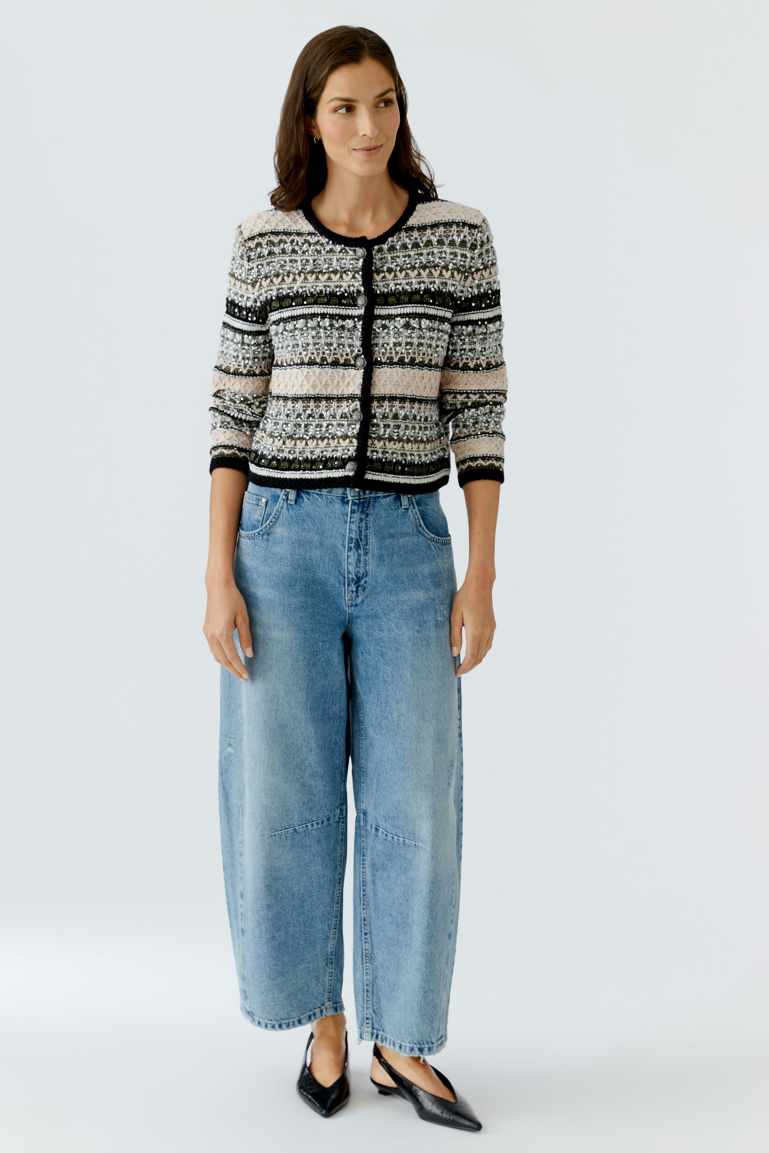 Casual women's cardigan: A woman in a patterned cardigan paired with wide jeans, exuding a relaxed vibe.