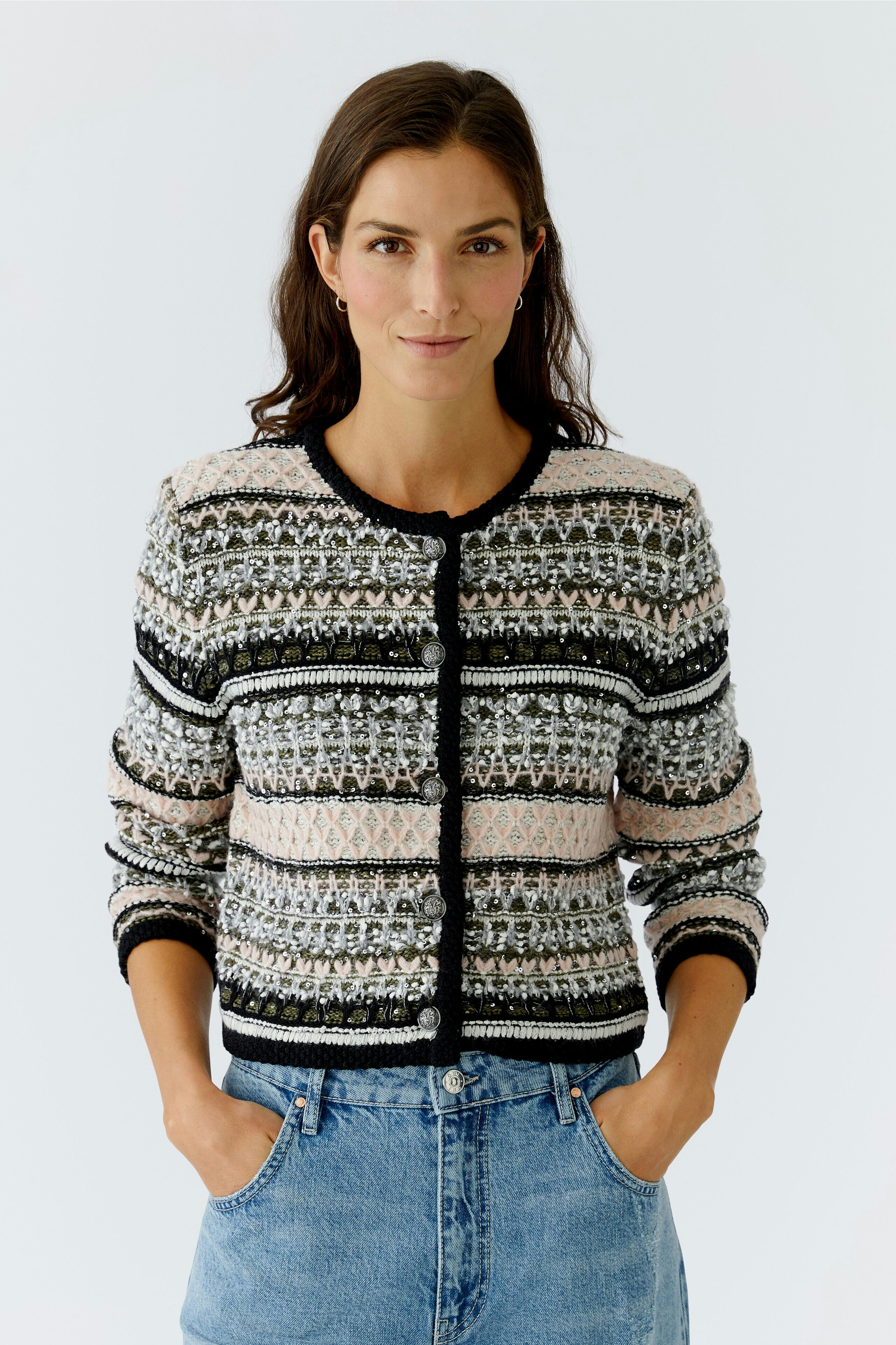 Casual women's cardigan: A woman in a patterned cardigan with buttons, paired with denim jeans.