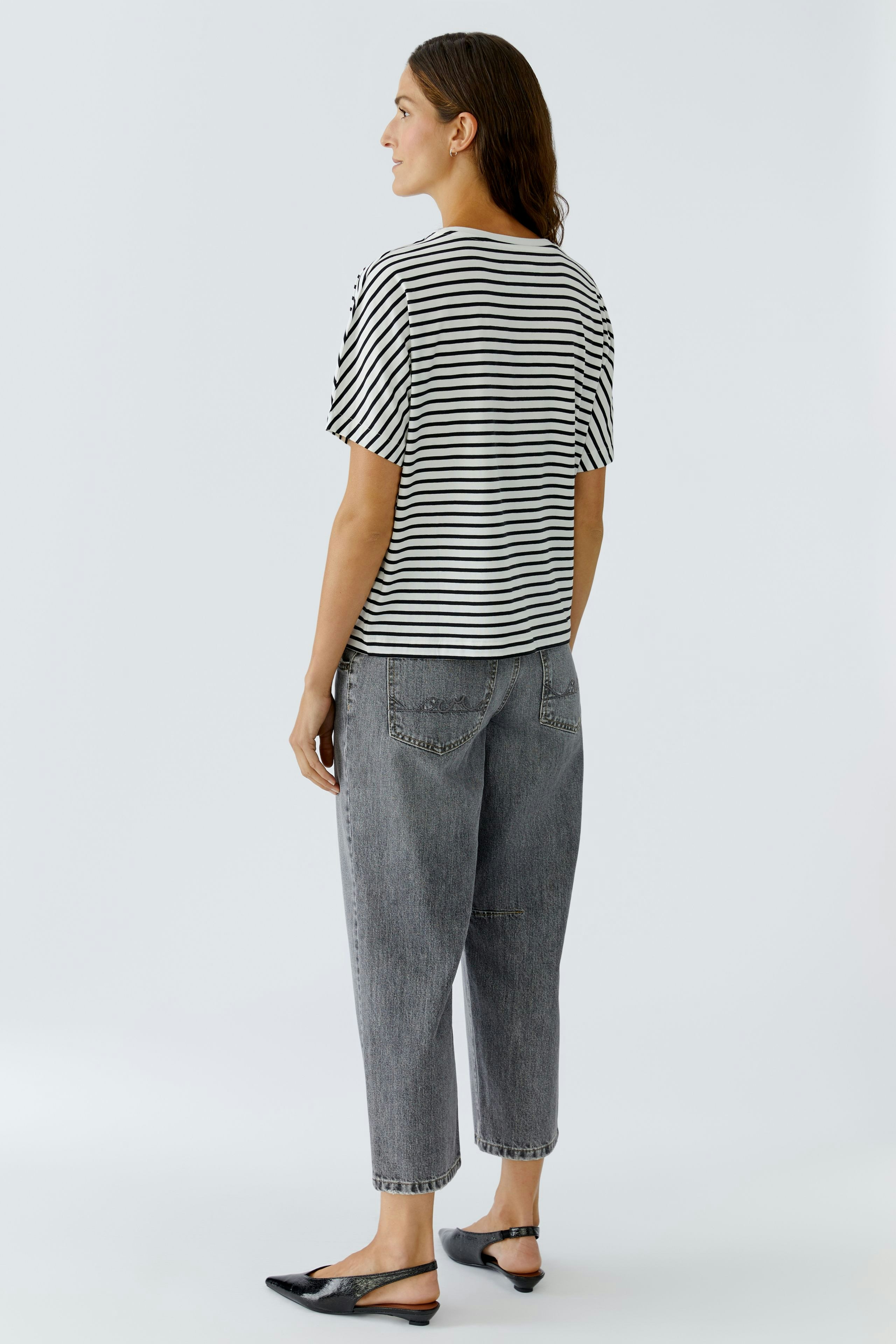 Casual women's T-shirt: A woman in a striped tee with short sleeves and relaxed fit, paired with loose jeans.