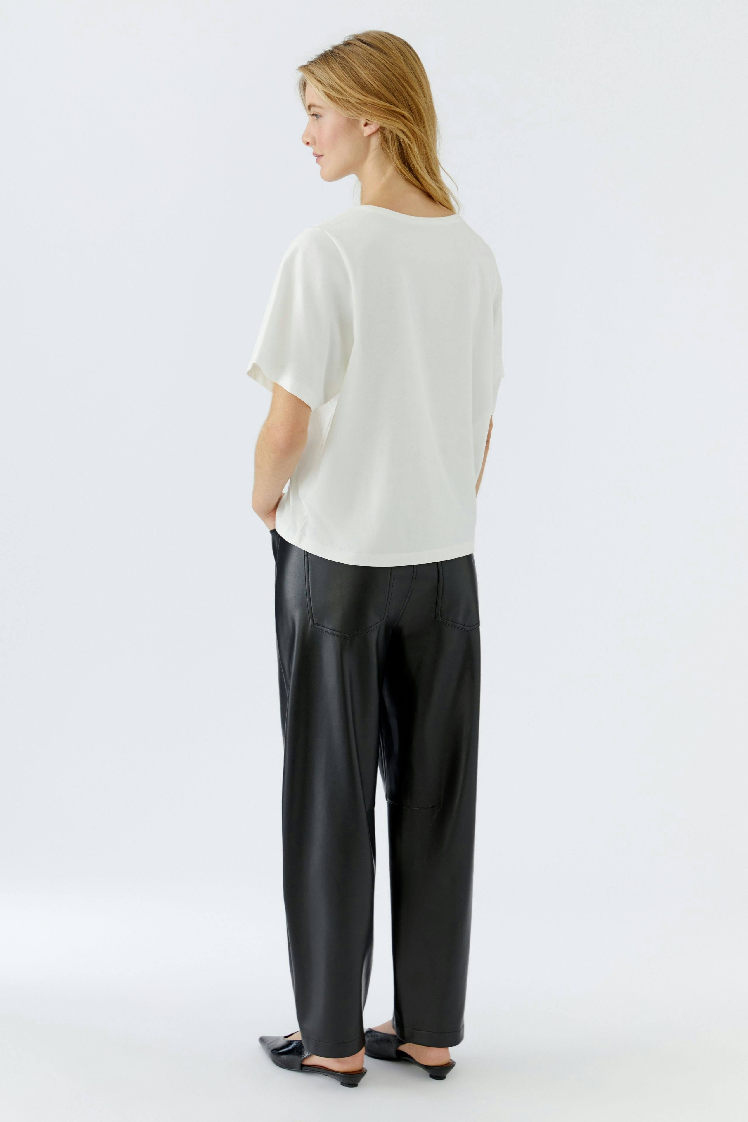 Casual women's T-shirt: A woman in a white T-shirt with a relaxed fit, paired with black pants.