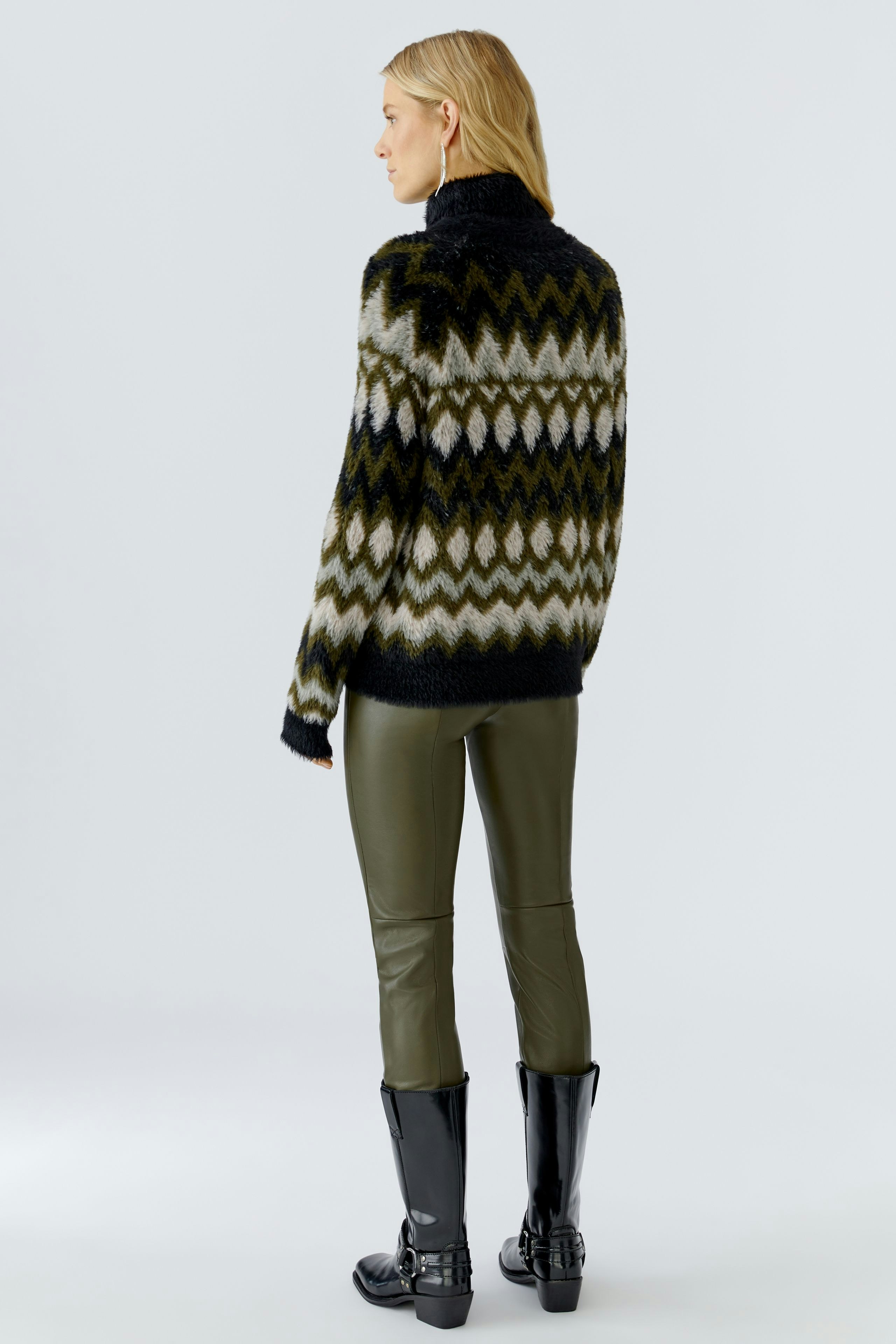 Casual women's pullover: A woman in a patterned pullover with a high collar and stylish pants.