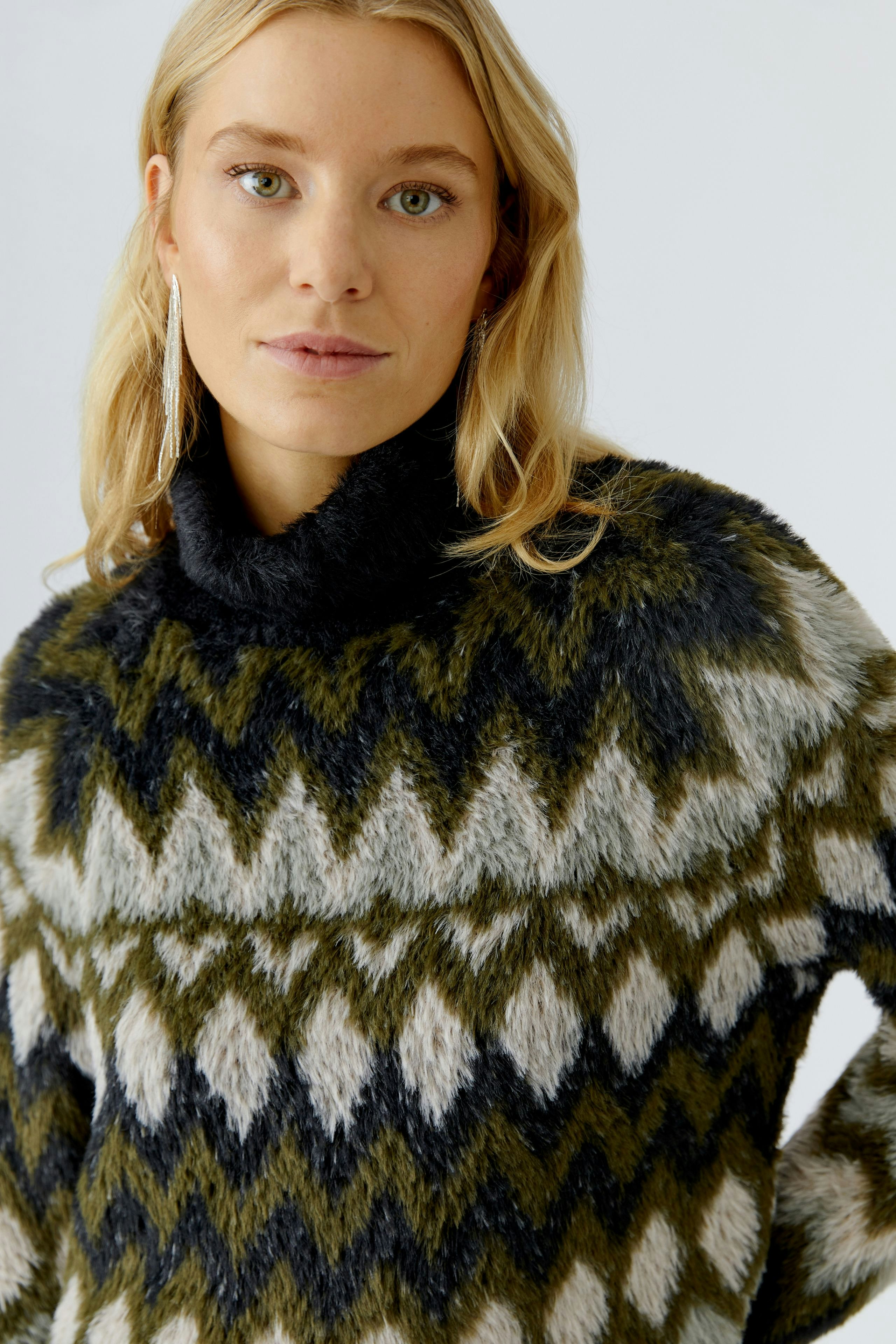 Cozy women's pullover with a geometric pattern, featuring a high collar and soft texture.