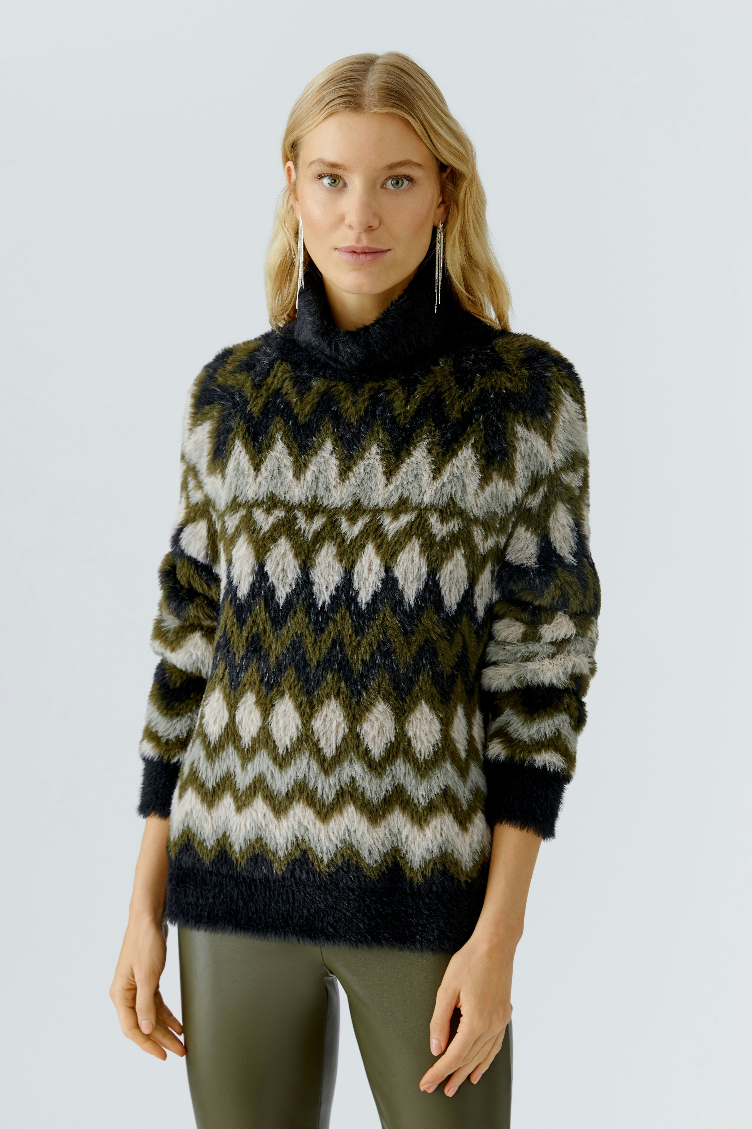Cozy women's pullover: A woman in a patterned, oversized pullover with a high collar.