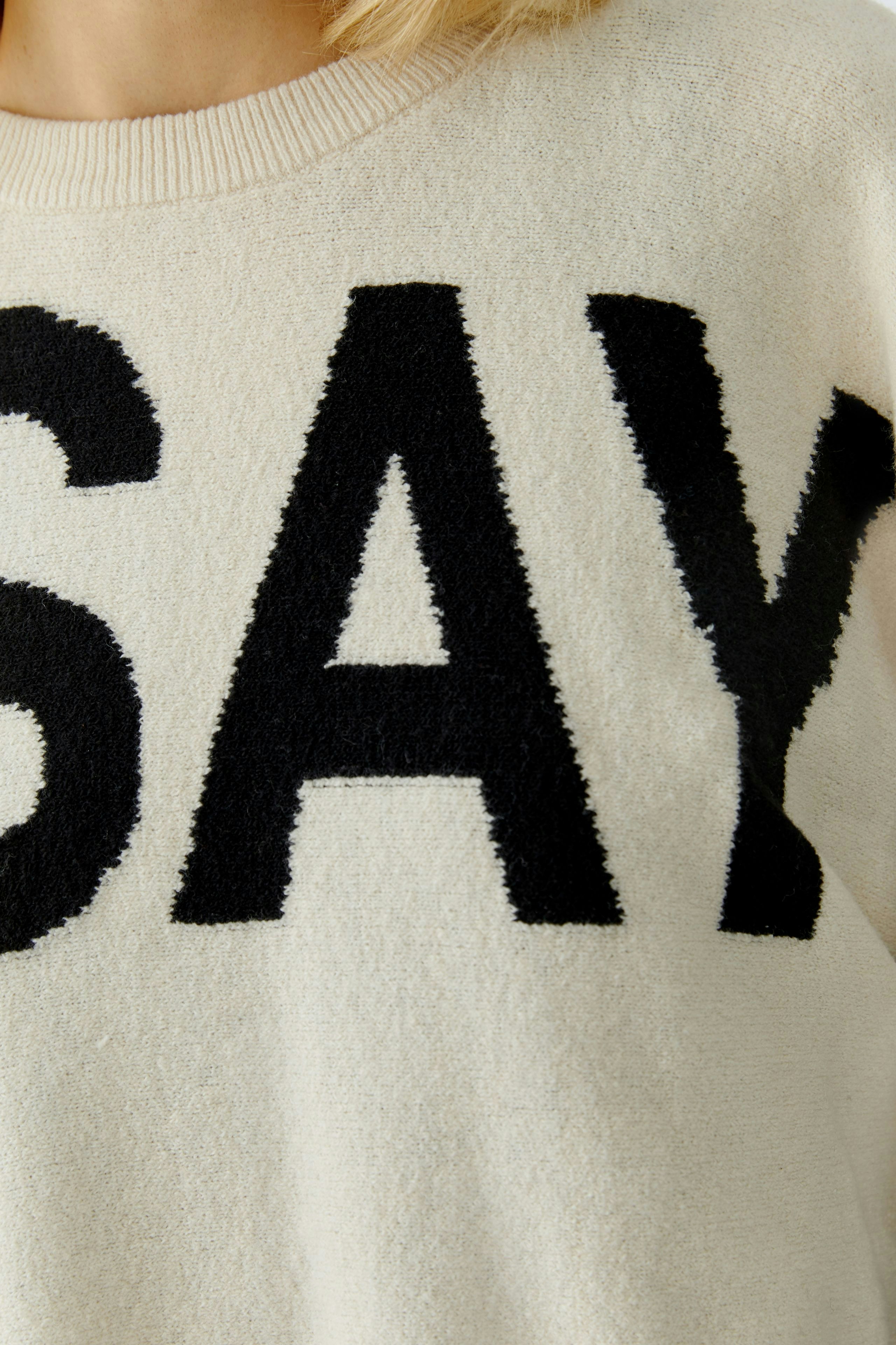 Bequemer Damen-Pullover in Creme mit schwarzem Schriftzug. Ideal für lässige Outfits.