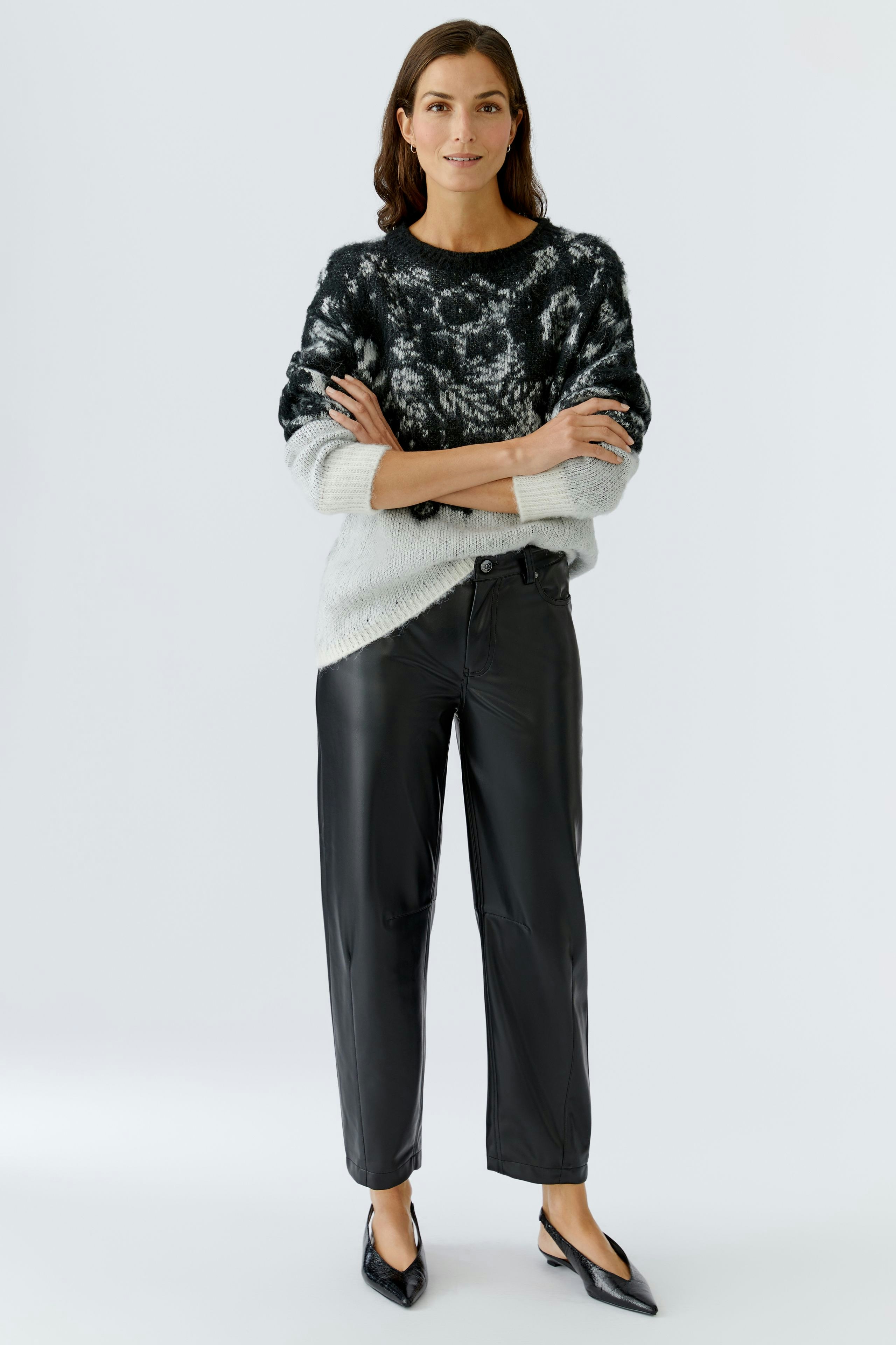Casual women's pullover: A woman in a black and white patterned pullover with relaxed fit.