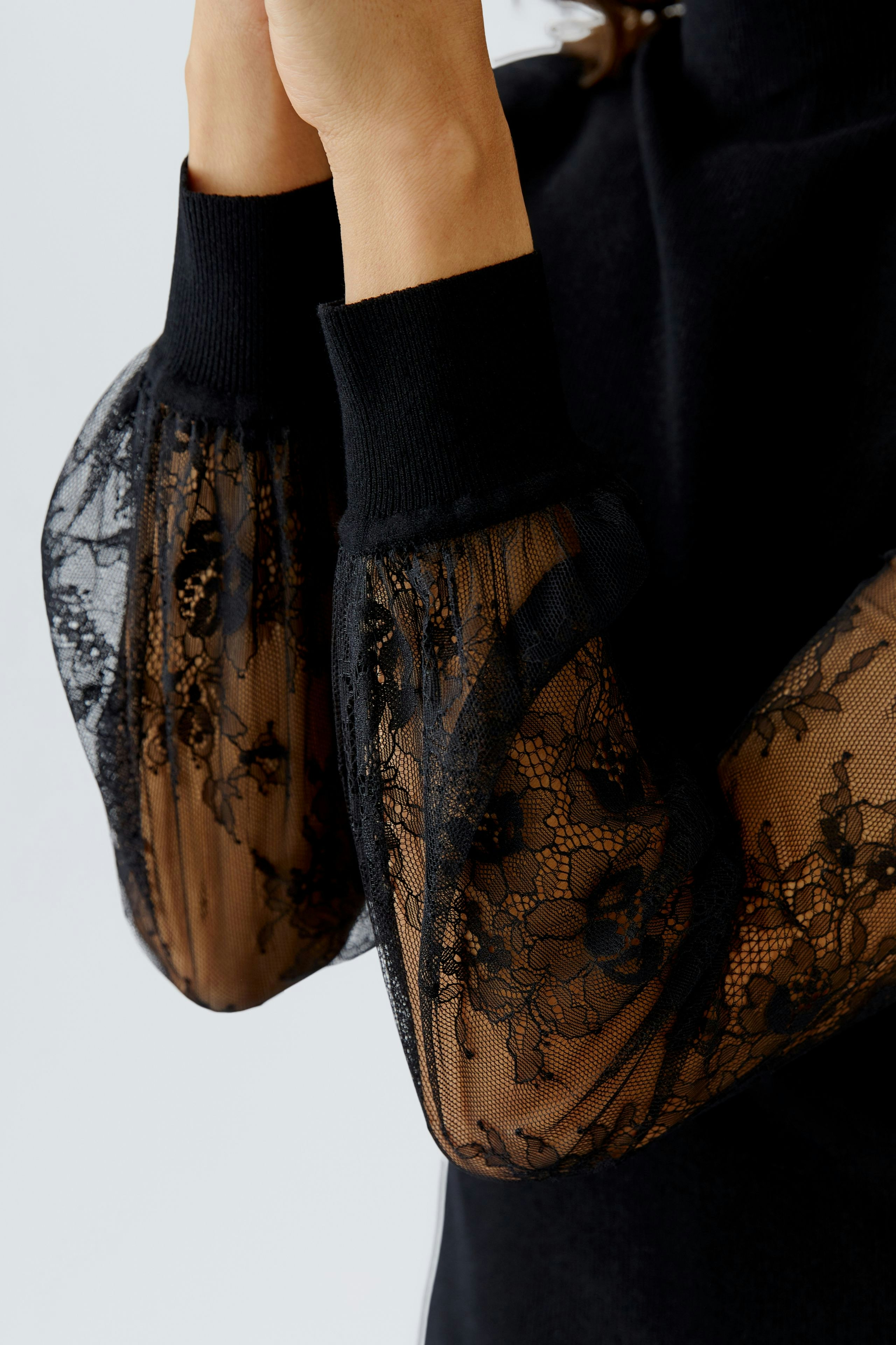 Stylish women's pullover: Close-up of a black pullover with lace puff sleeves, perfect for casual wear.