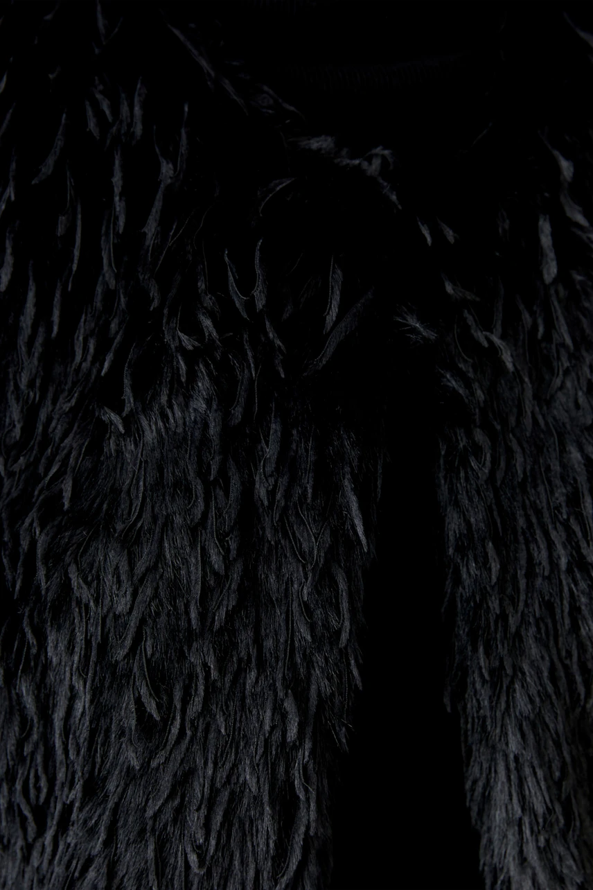 Schwarze Damen-Weste aus weichem Material mit fransigem Design, ideal für lässige Outfits.