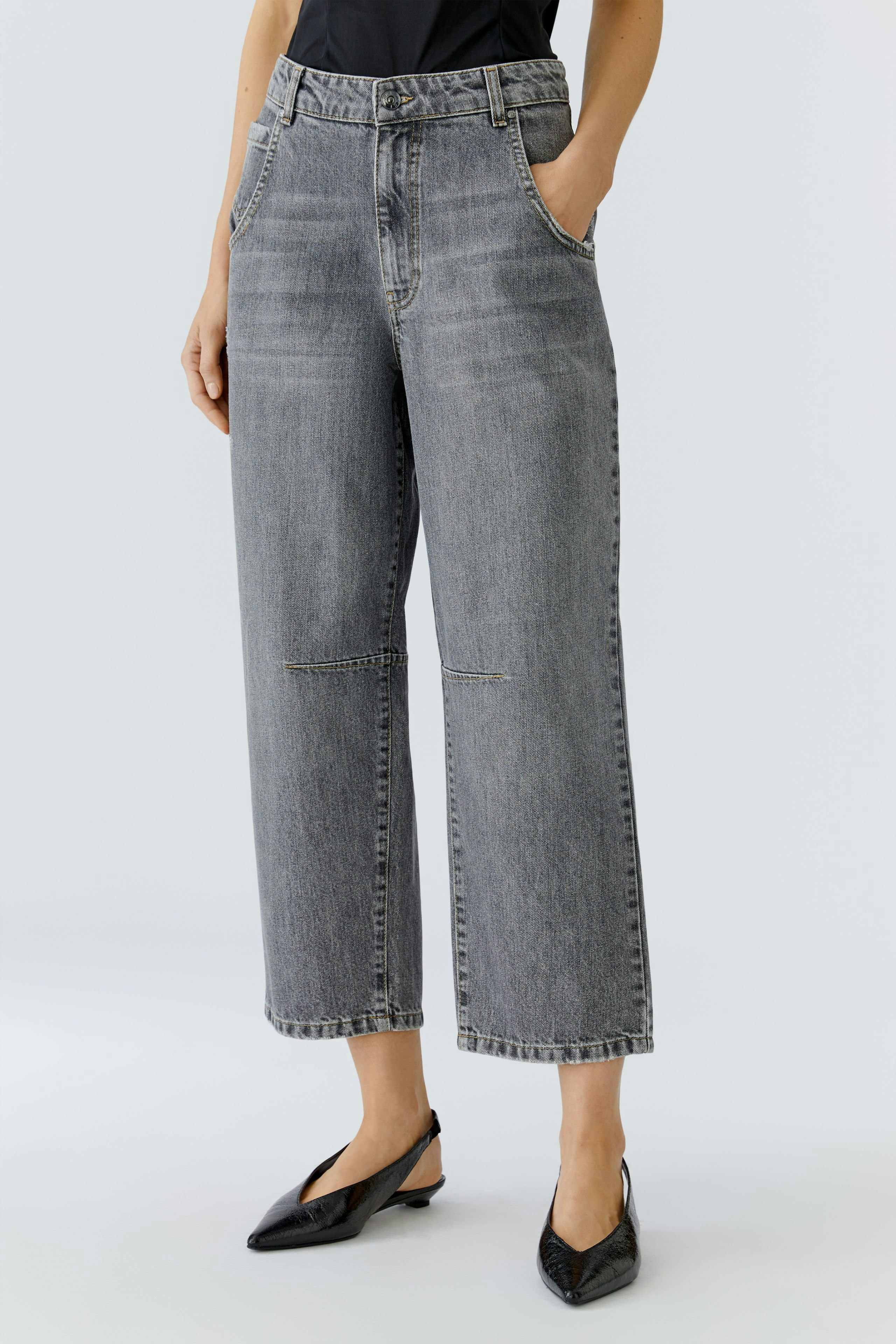 Casual women's jeans: A woman in gray barrel jeans with a relaxed fit and pockets stands confidently.