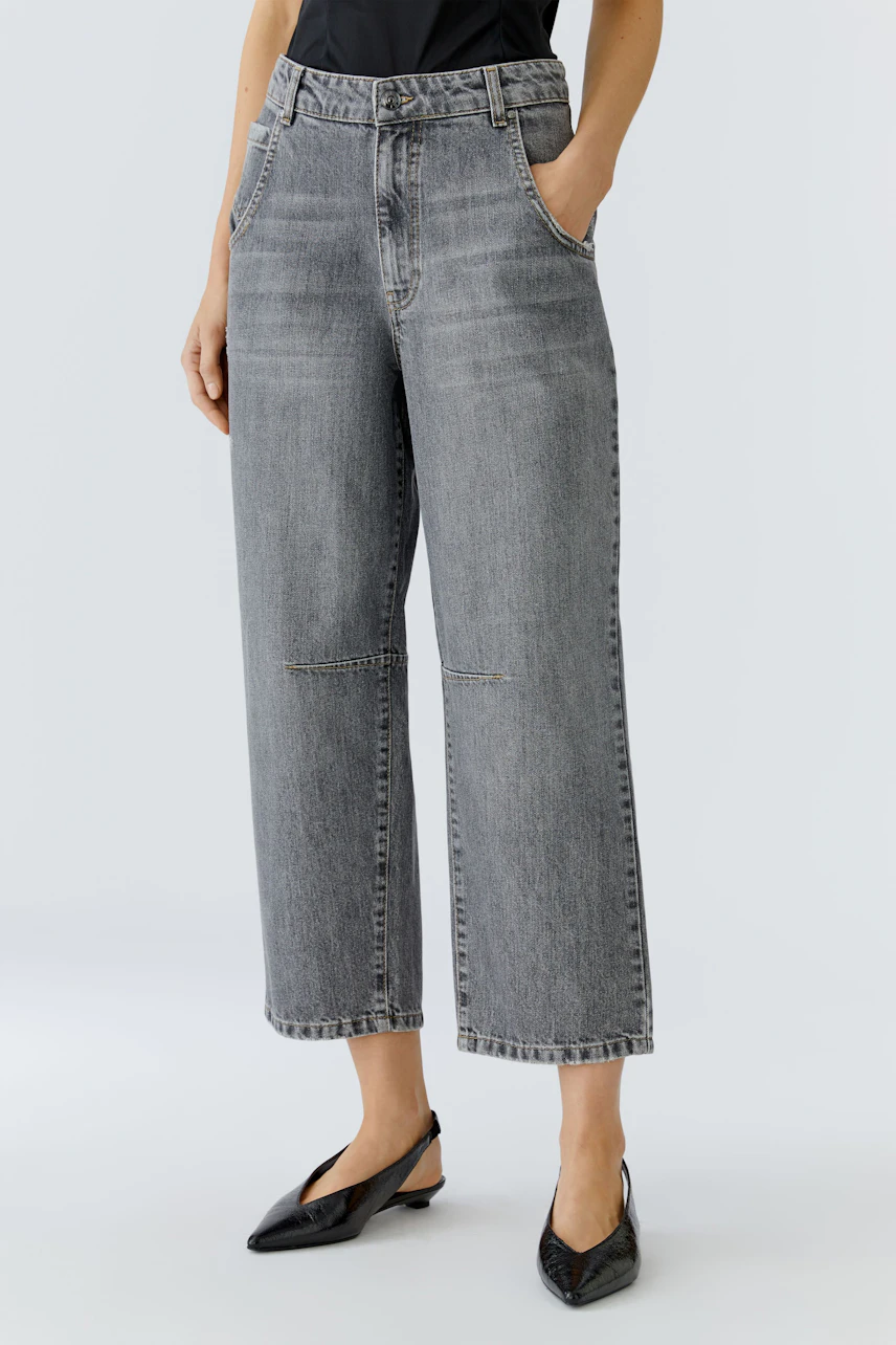 Casual women's jeans: A woman in gray barrel jeans with a relaxed fit and pockets stands confidently.