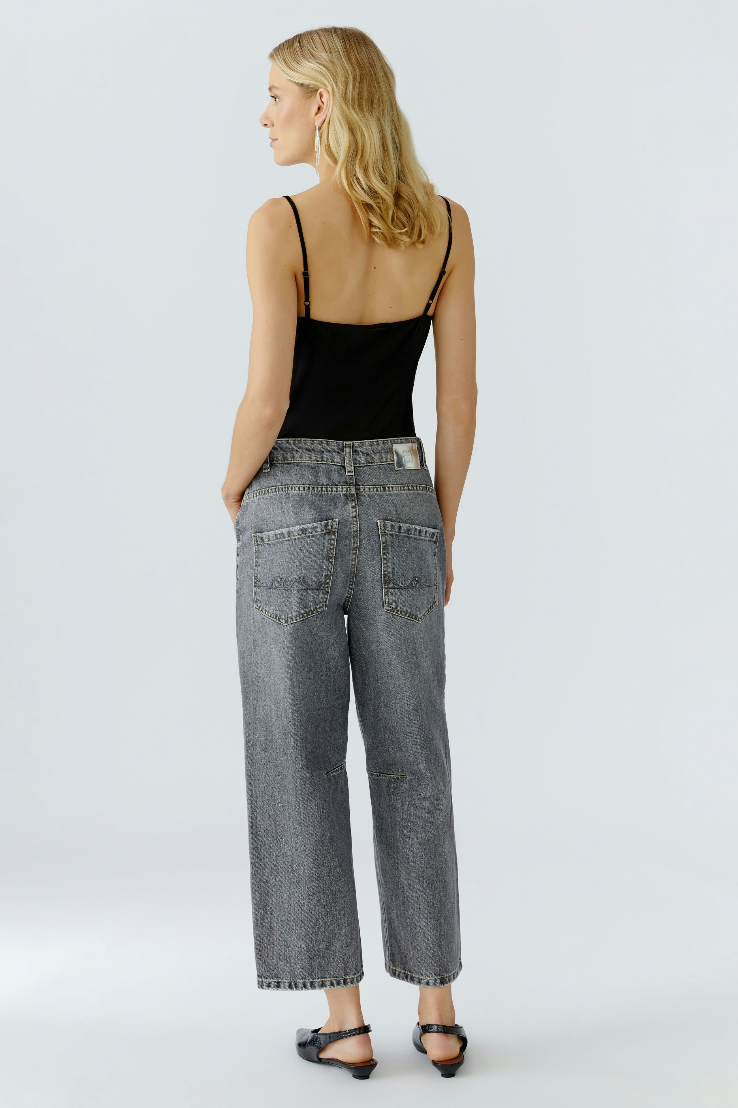 Casual women's jeans barrel: A woman in gray jeans with a relaxed fit, showcasing a simple style.