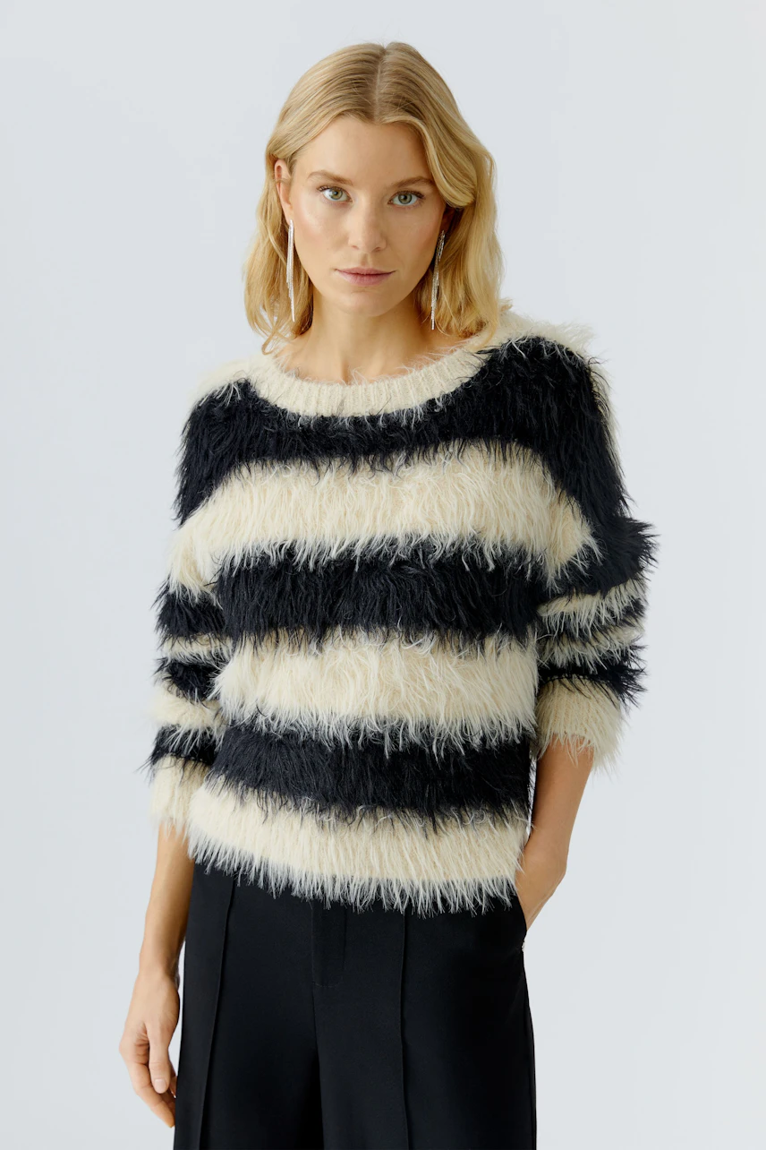 Casual women's pullover: A woman in a fluffy striped pullover with black and cream colors.