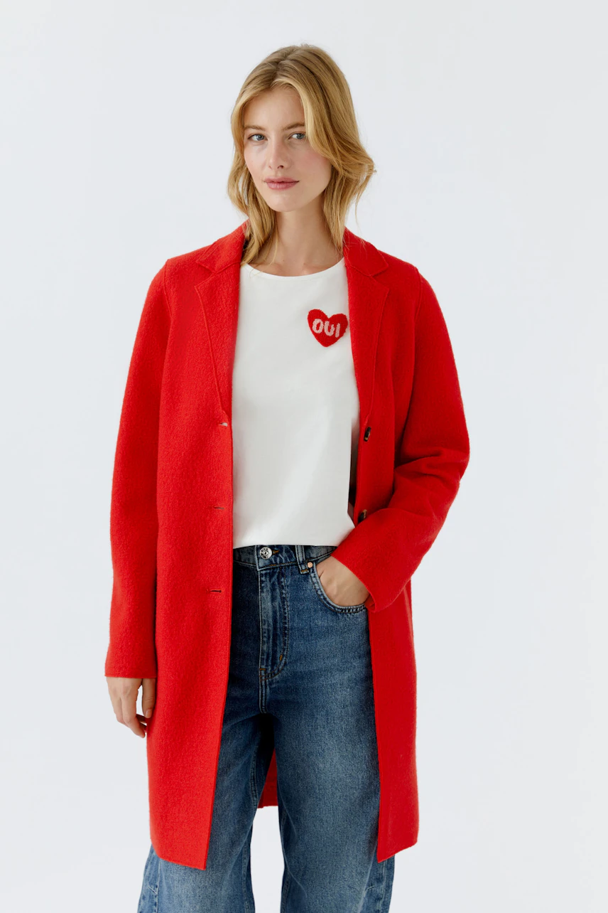 Stylish women's wool coat in vibrant red, paired with a white tee and relaxed jeans.