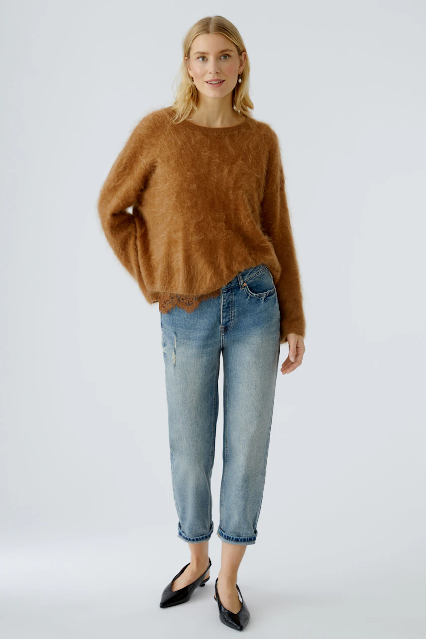 Casual women's pullover: A woman in a cozy brown pullover paired with relaxed jeans.