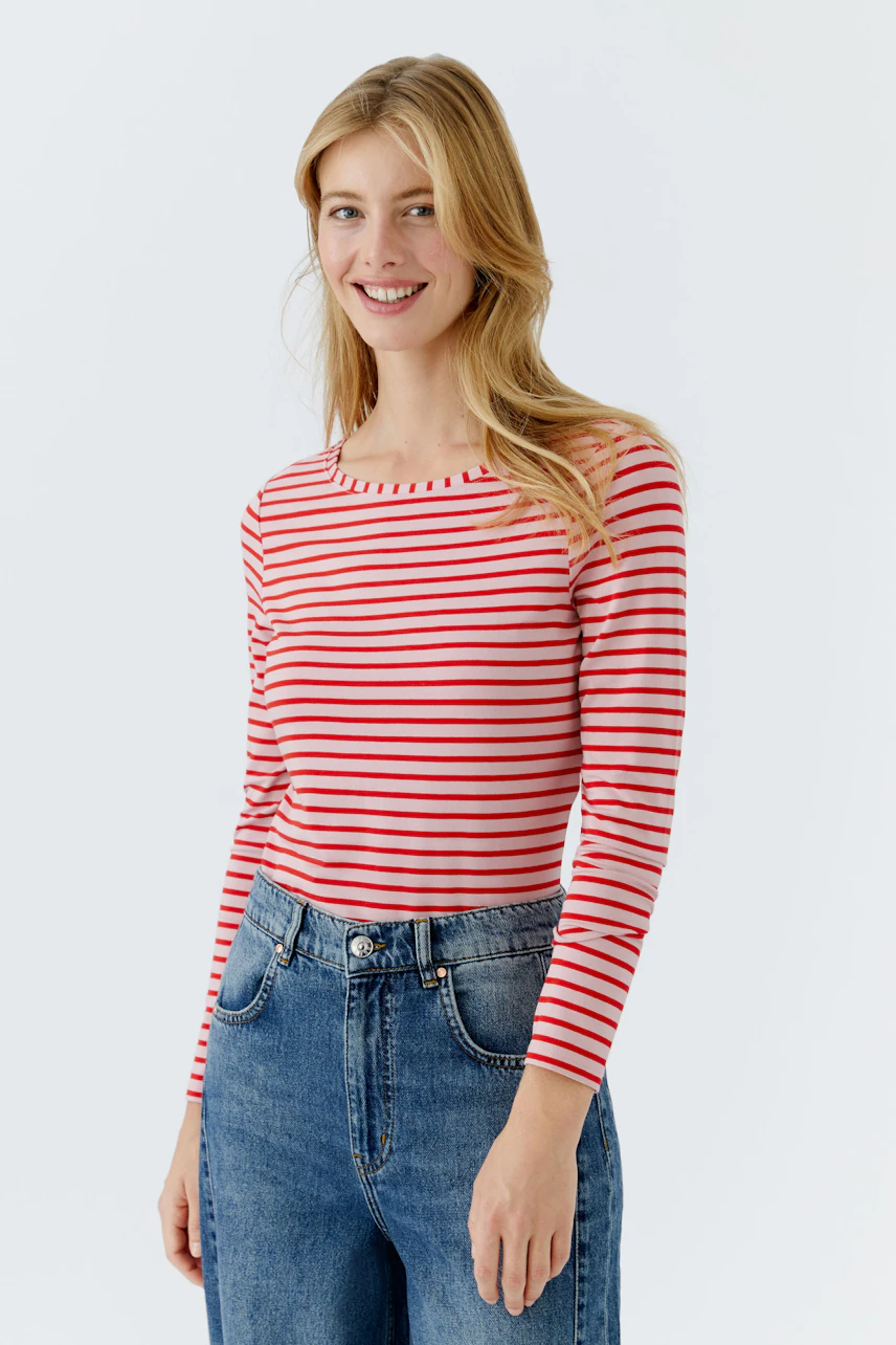 Casual long-sleeve shirt: Woman in a red and white striped shirt paired with high-waisted jeans.