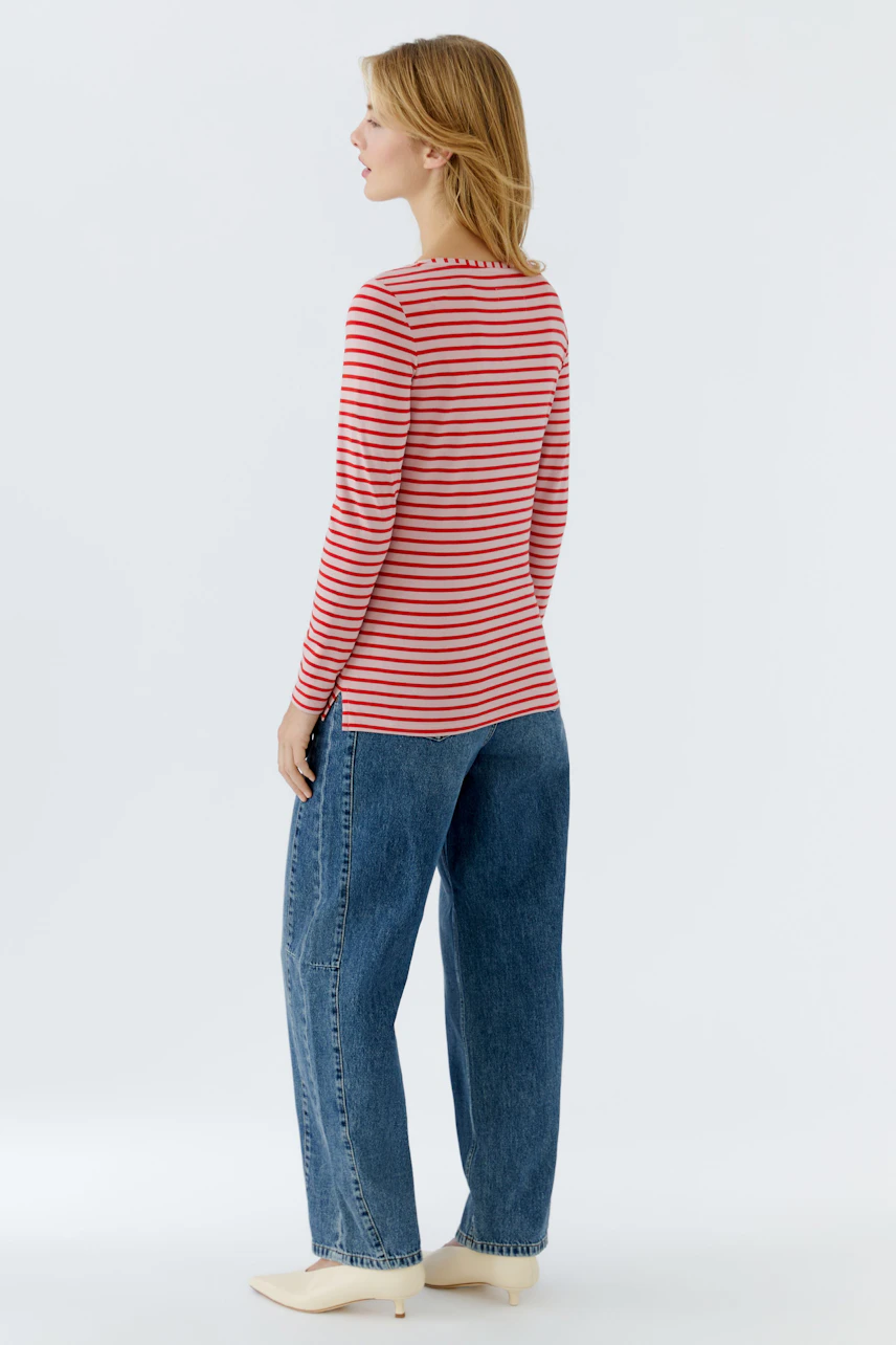 Casual long-sleeve shirt: Woman in a red and white striped shirt paired with relaxed-fit jeans.