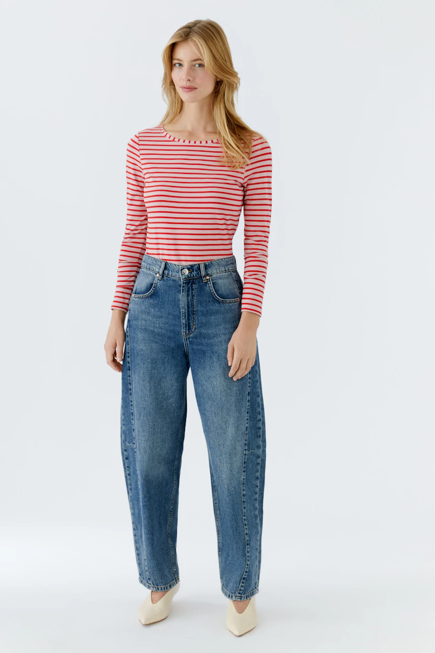 Casual long-sleeve shirt: Young woman in a red and white striped shirt paired with relaxed-fit jeans.