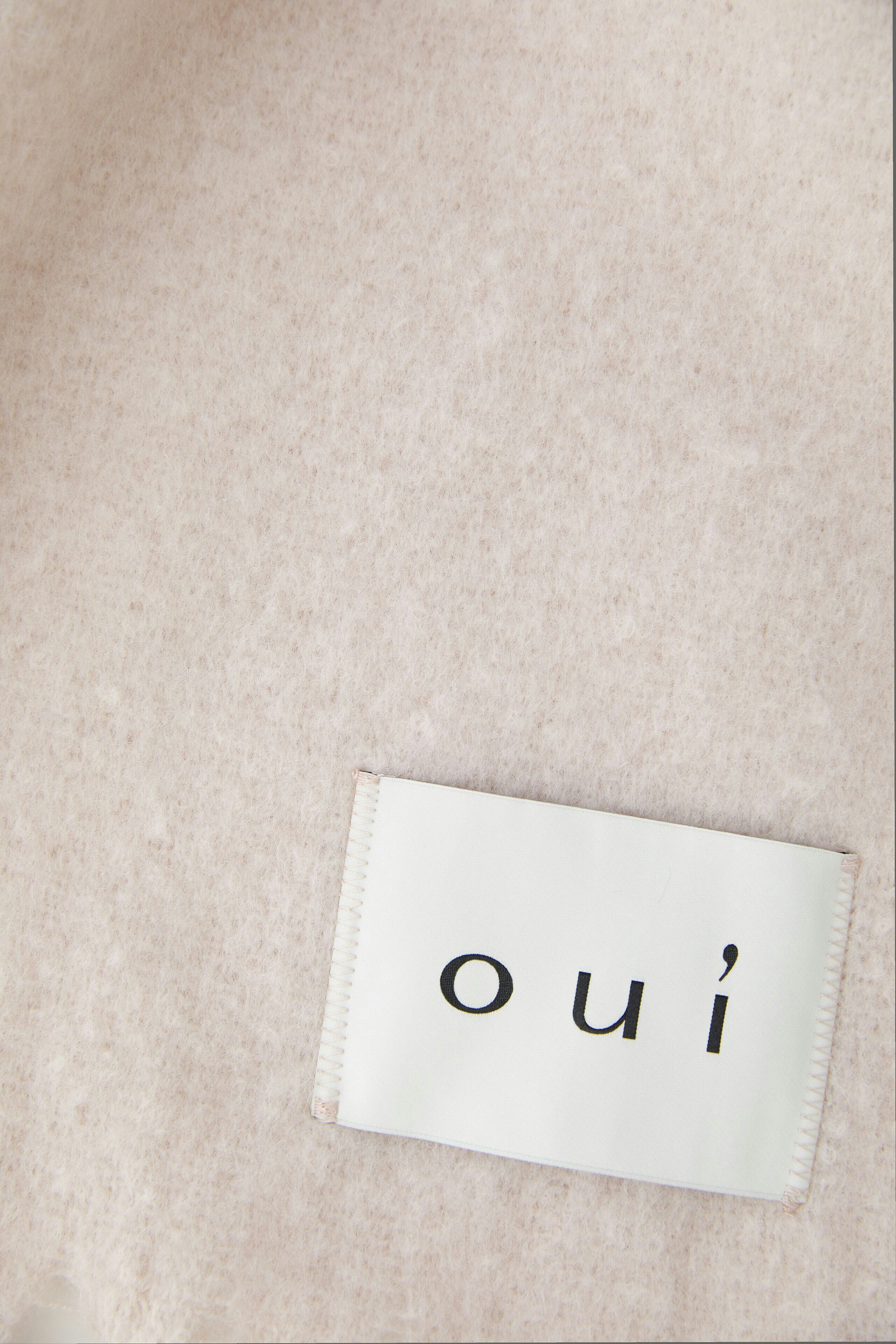 Weicher Damen-Schal in zartem Rosa, lässig um den Hals drapiert, ergänzt den Look.