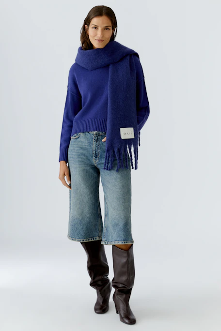 Soft women's scarf in deep blue with fringes, perfect for layering in cooler weather.
