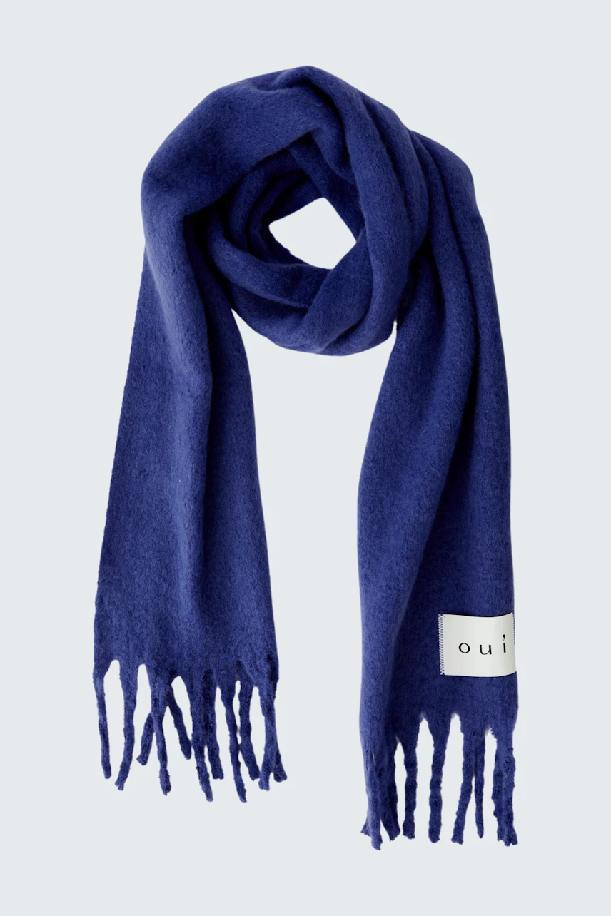Soft women's scarf in deep blue with fringes, perfect for layering in cooler weather.