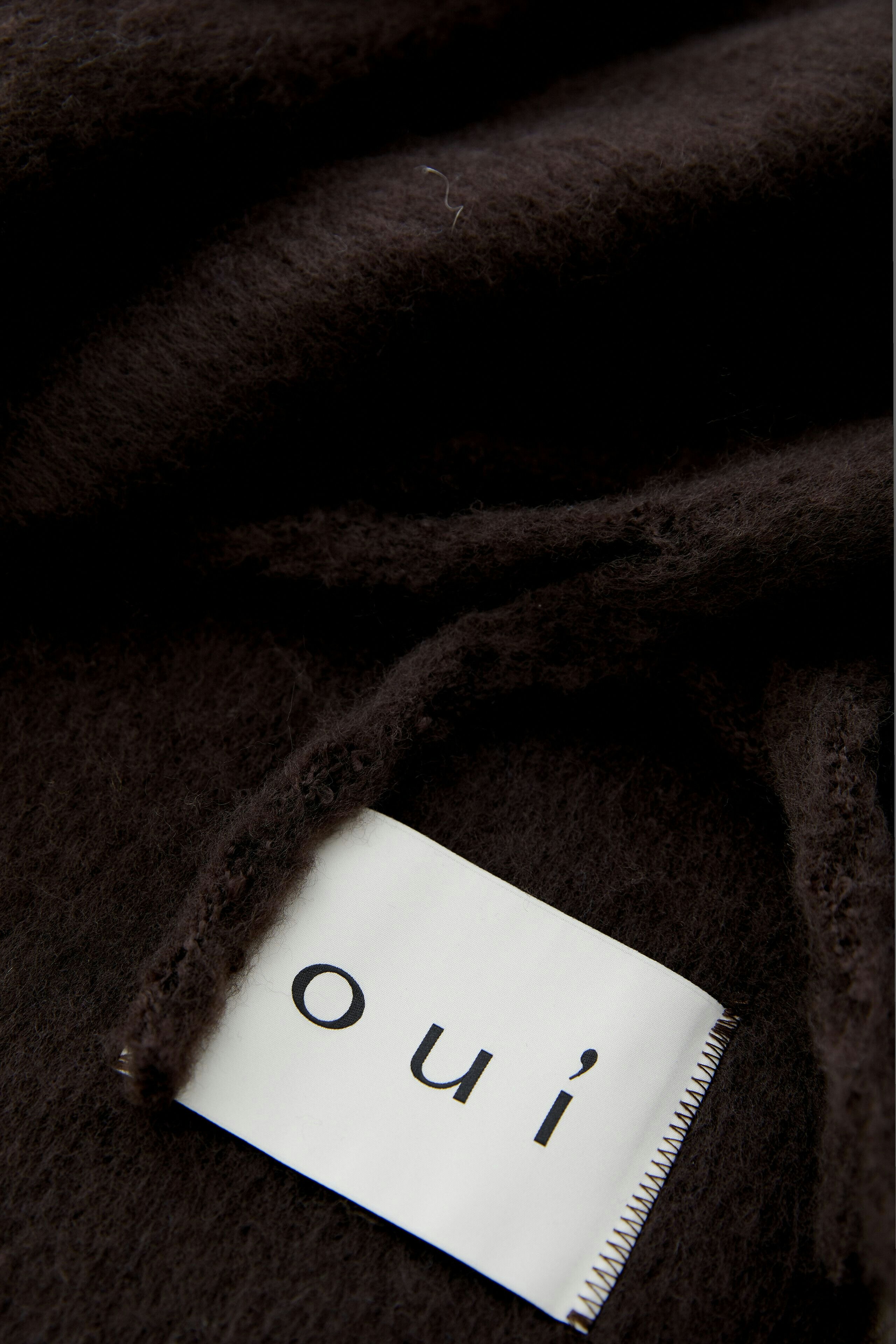 Damen-Schal in Braun: Frau trägt einen weichen, langen Schal, kombiniert mit einem lässigen Outfit.