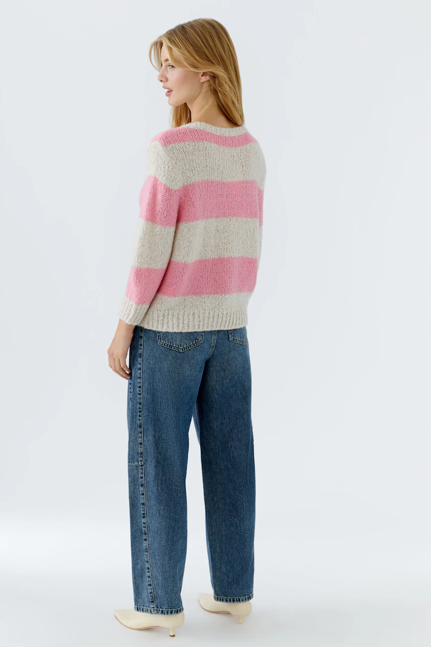 Damen-Pullover in rosa-gestreift: Frau mit lässigem Look, trägt den Pullover zu weiten Jeans.