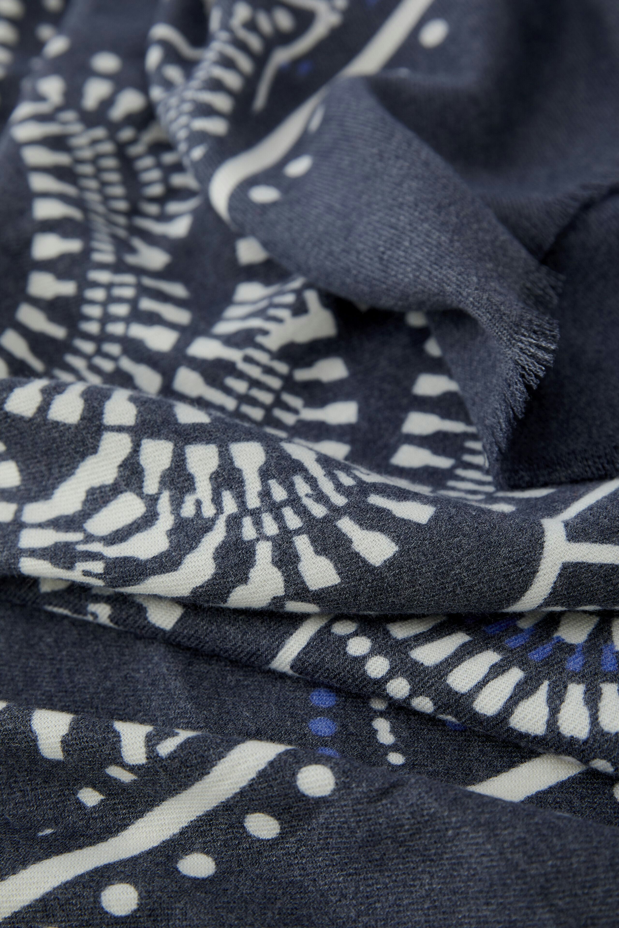 Stylish scarf: Close-up of a soft scarf with a navy and white pattern, perfect for layering.