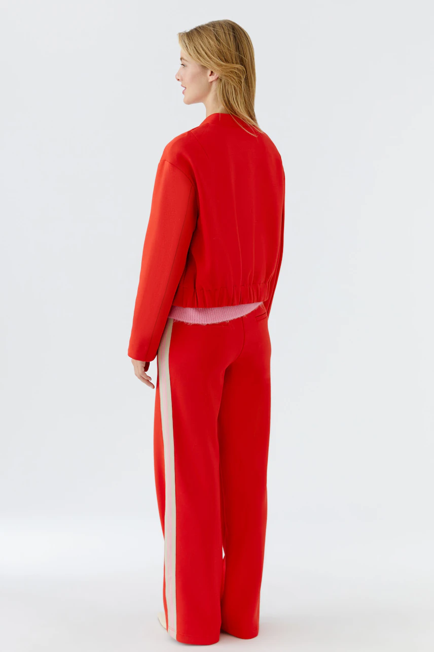 Damen-Blouson: Frau in rotem Blouson mit elastischem Bund und lässiger Passform von hinten.