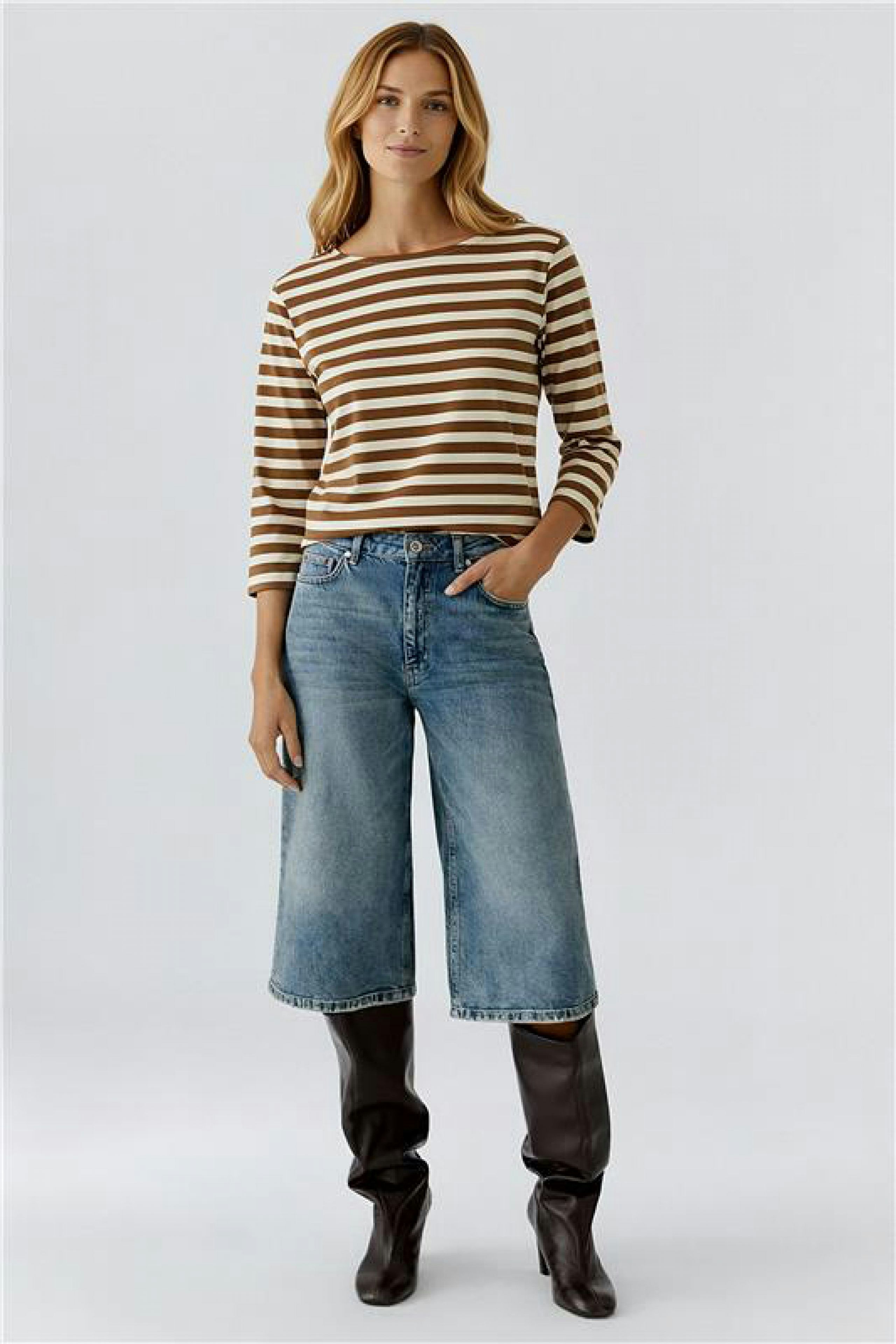 Casual women's T-shirt: A woman in a striped brown and white T-shirt paired with wide jeans.