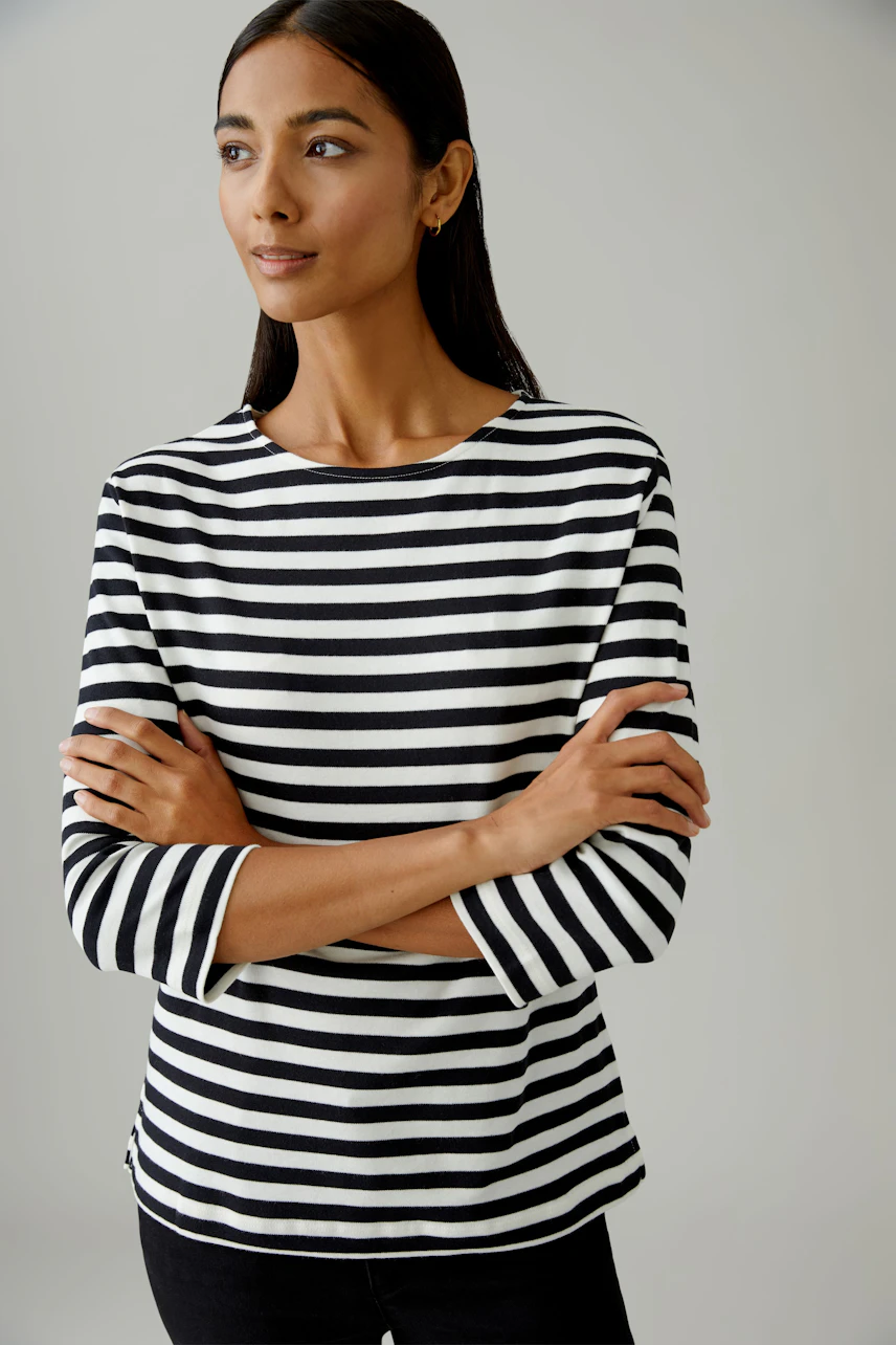 Casual women's T-shirt: A woman in a black and white striped top with three-quarter sleeves.