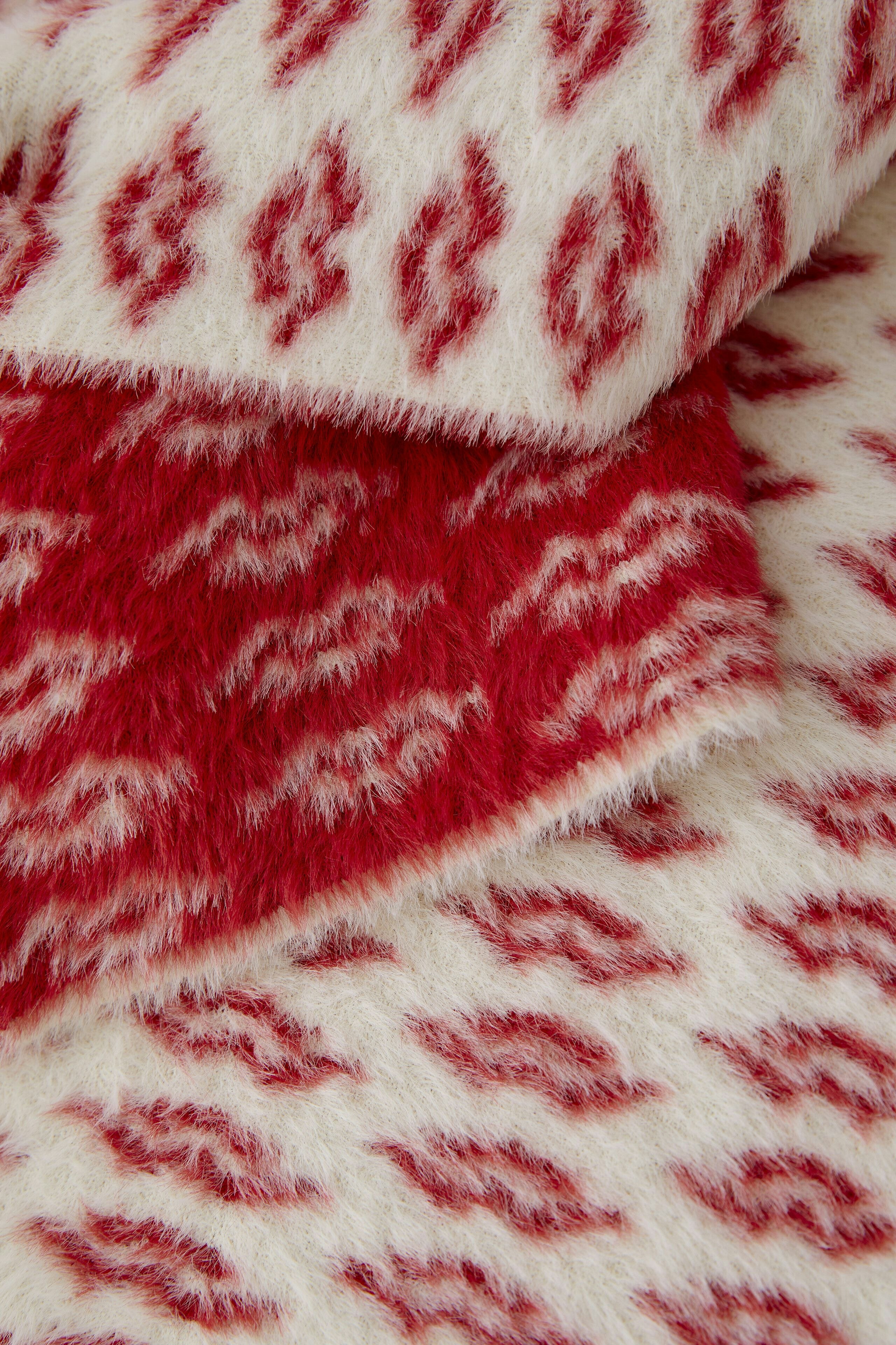 Cozy women's scarf in red and white pattern, perfect for adding warmth and style.