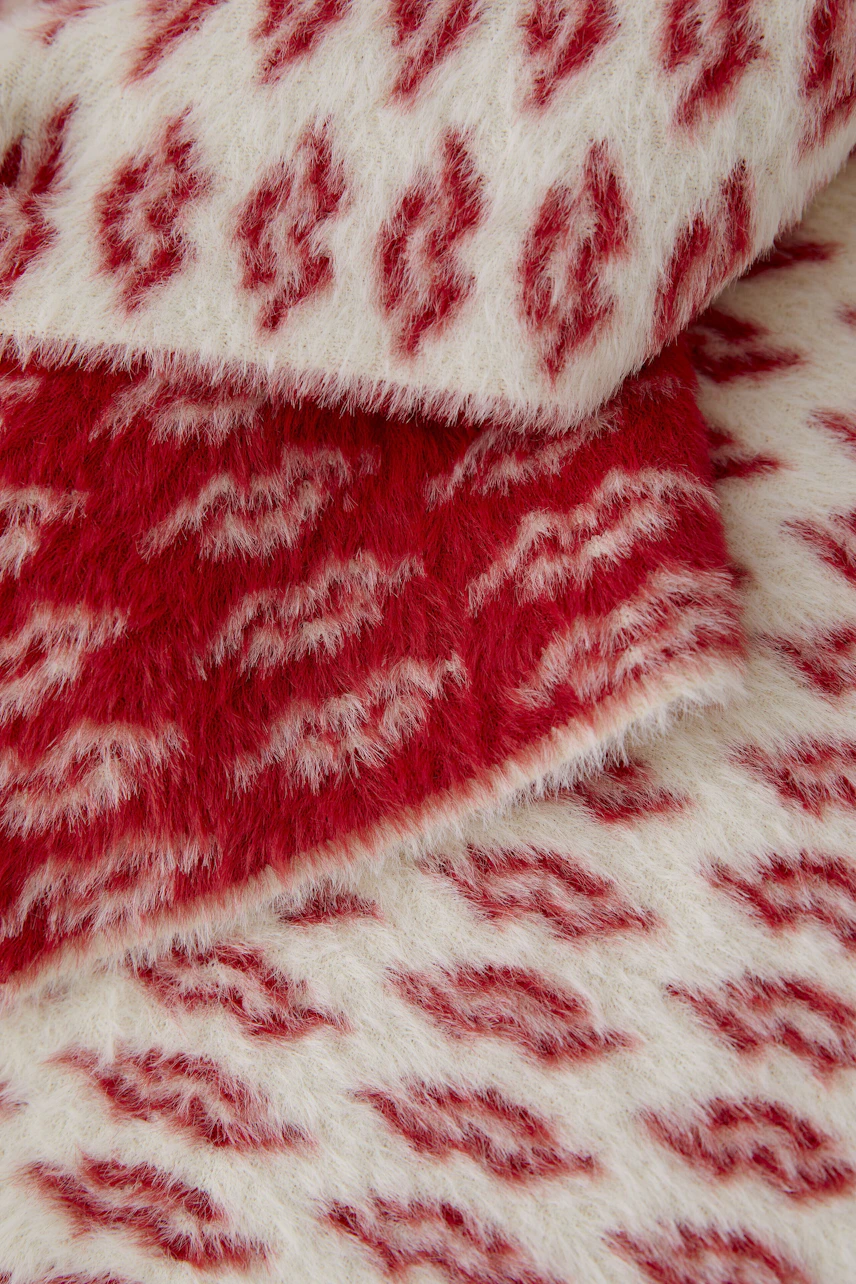 Cozy women's scarf in red and white pattern, perfect for adding warmth and style.
