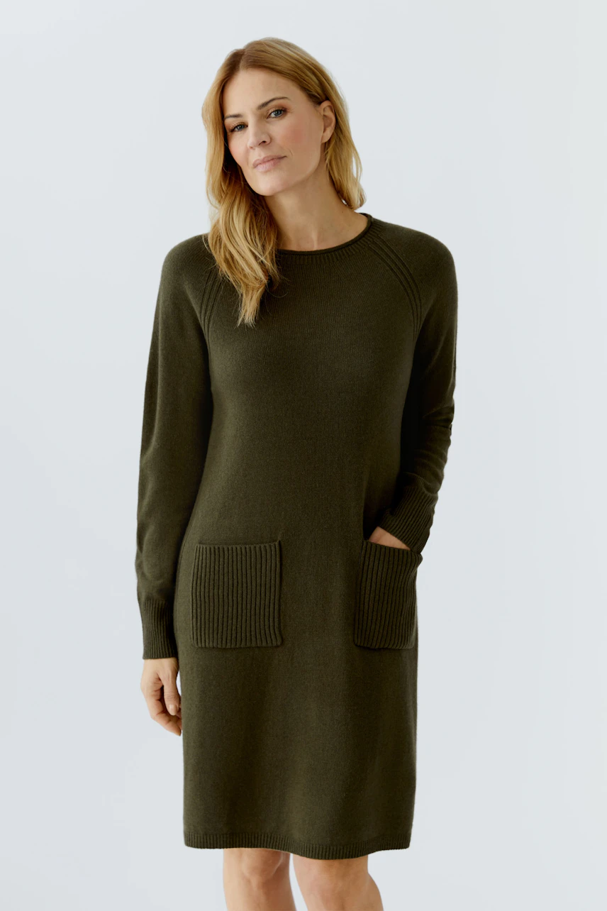 Casual women's knitted dress in olive green with ribbed pockets and long sleeves.