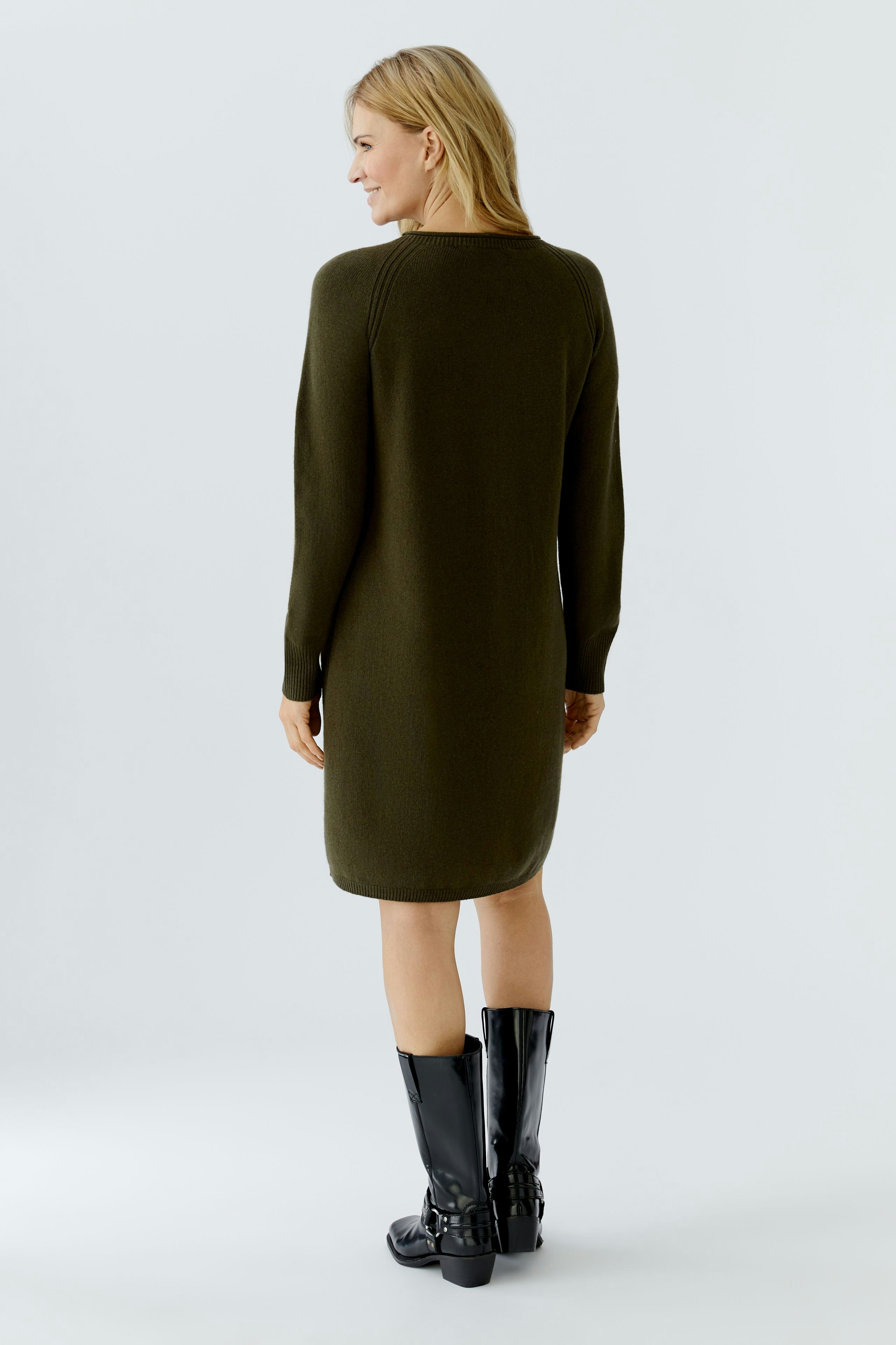 Casual women's knitted dress: A woman in a green knitted dress, showcasing a relaxed fit and long sleeves.